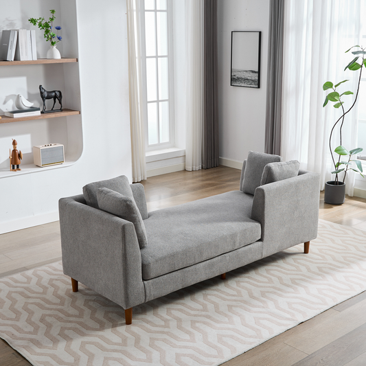Modern gray fabric chaise lounge with wooden legs and accent pillows