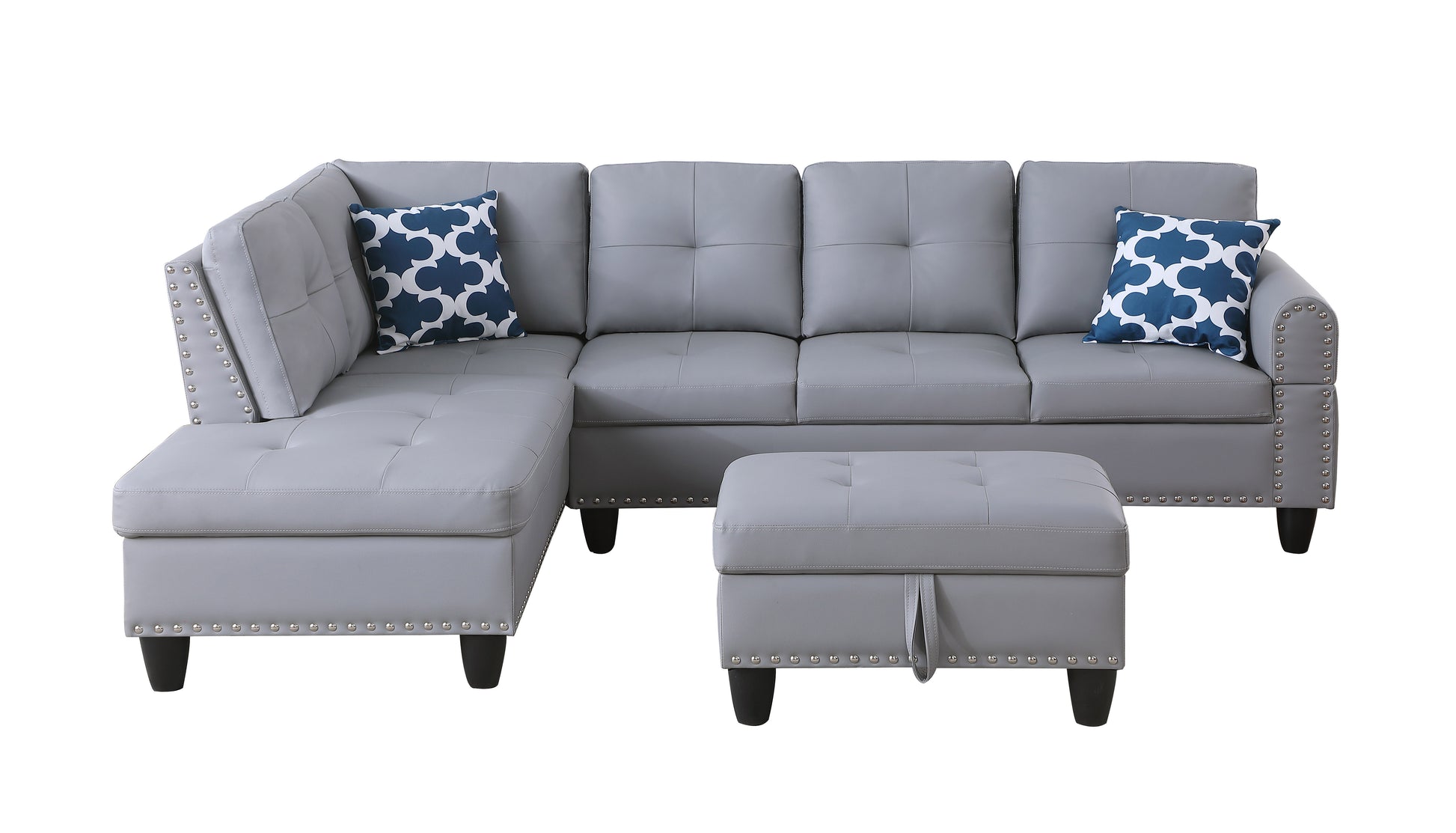 Grey tufted sectional sofa with decorative nailhead trim and blue patterned accent pillows