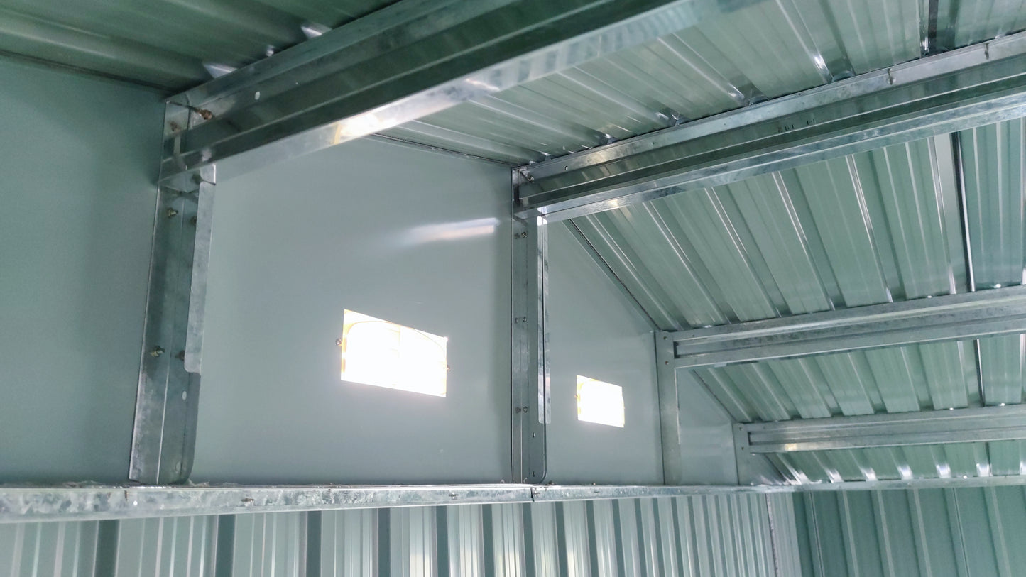 Green metal garden shed interior with corrugated roof and structural supports