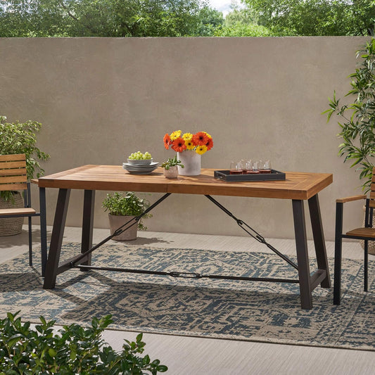 Wooden outdoor dining table with metal legs featuring fruit and drinks