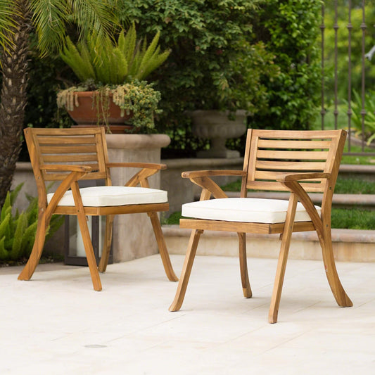 Two wooden patio chairs with cream cushions offer comfortable outdoor seating