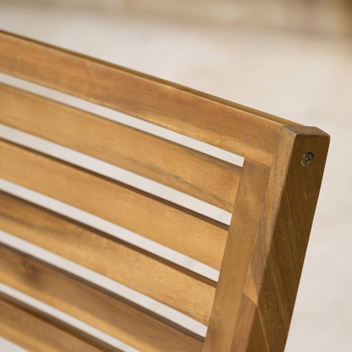 Closeup of a natural wood outdoor bench slatted backrest detail