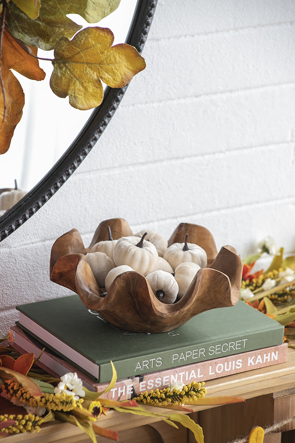 Wooden carved bowl filled with small white velvet pumpkins for autumn decor