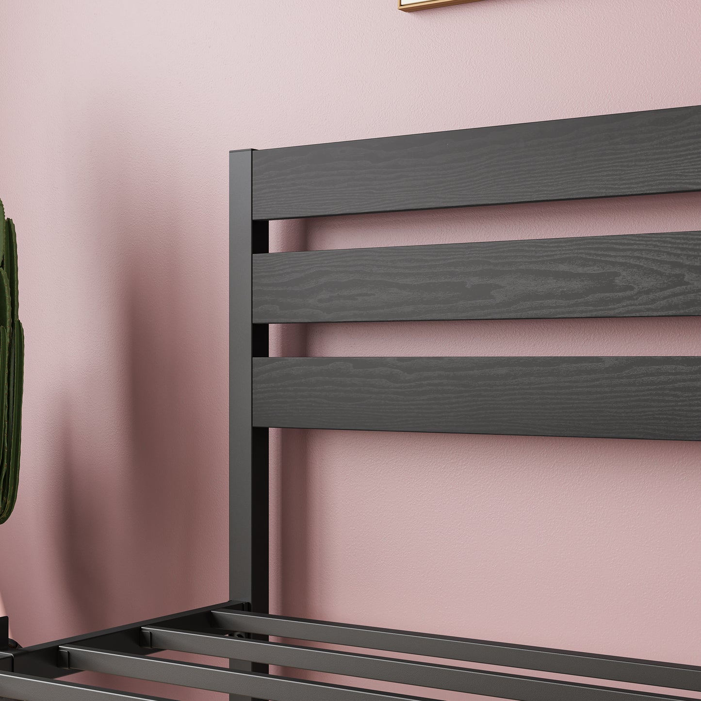 Dark grey wood slat headboard on a metal bed frame with a pink wall backdrop