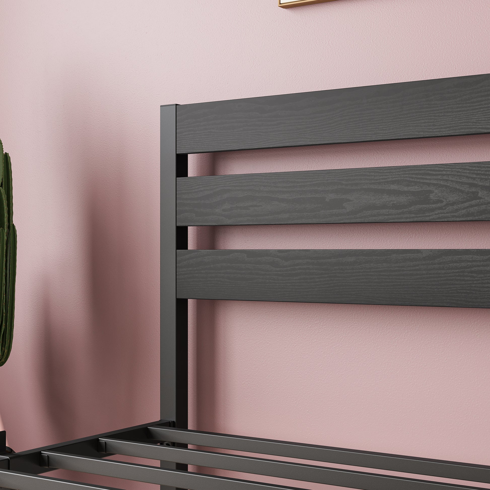 Dark grey wood slat headboard on a metal bed frame with a pink wall backdrop
