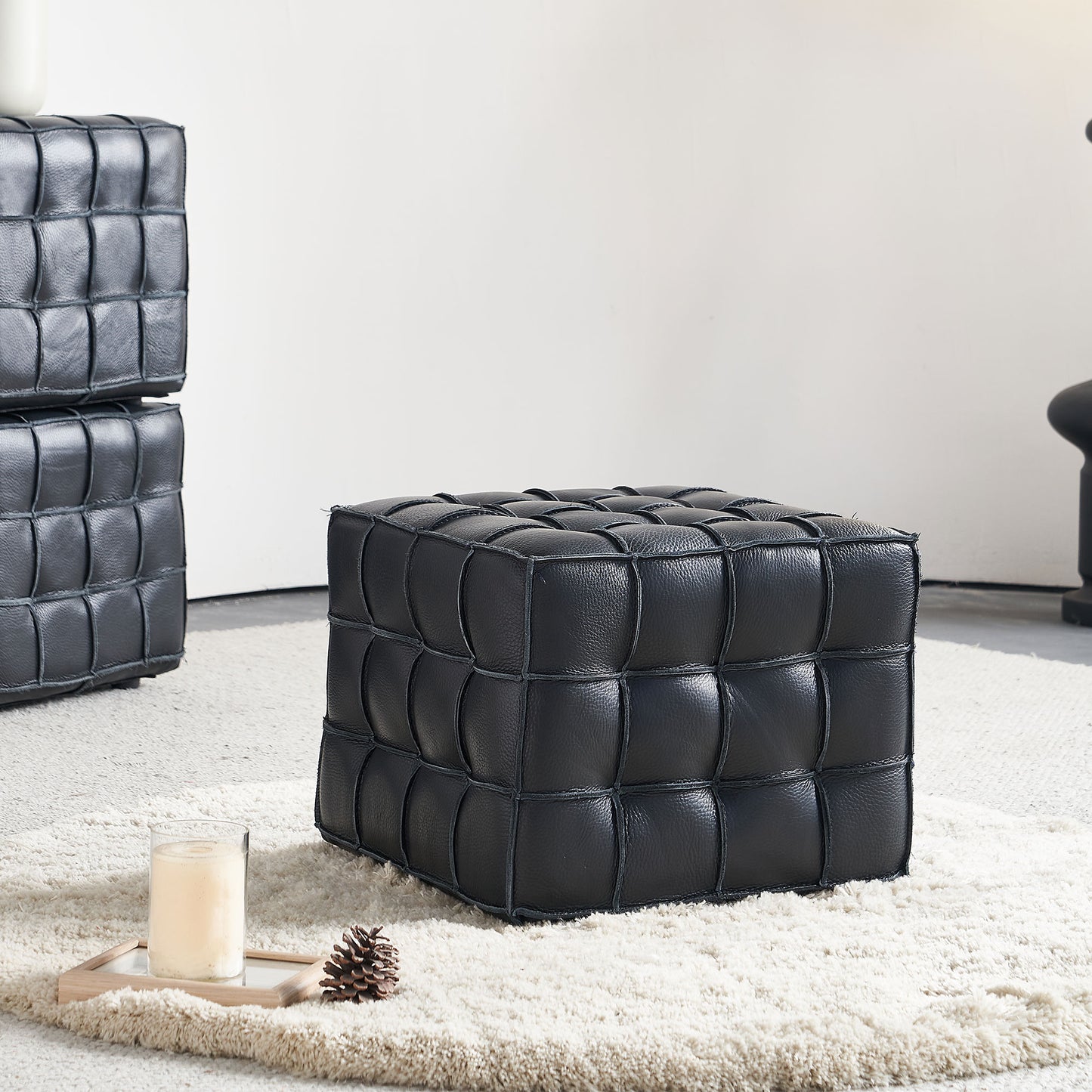 Black leather cube ottoman with quilted stitching detail perfect for a modern living room