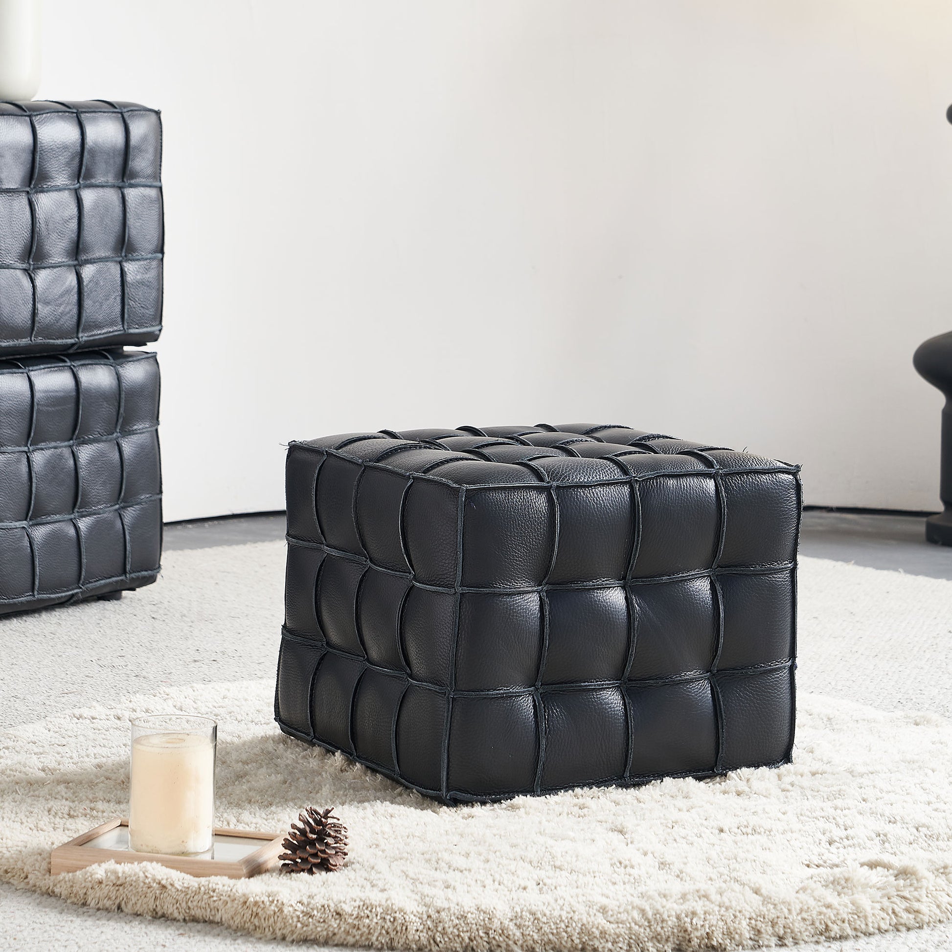 Black leather cube ottoman with quilted stitching detail perfect for a modern living room