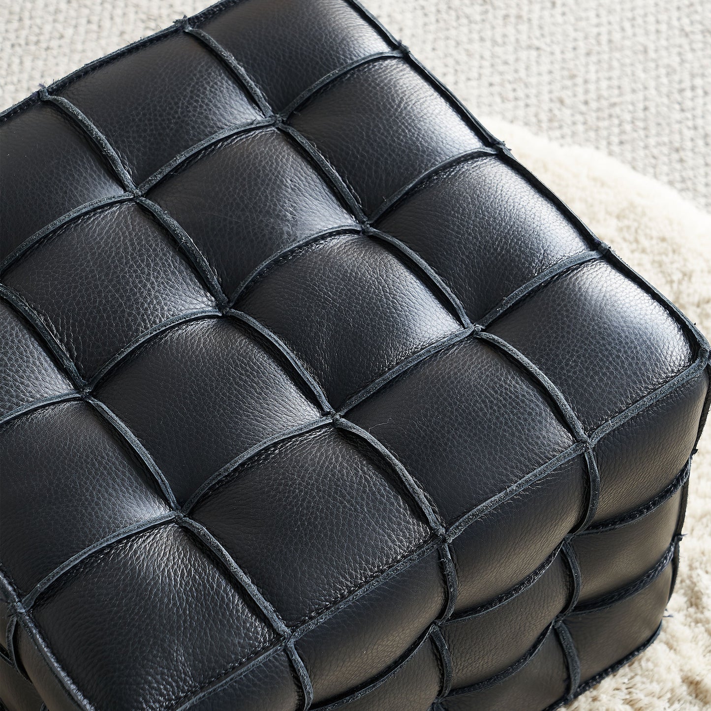 Black woven leather ottoman with diamond tufting for stylish seating