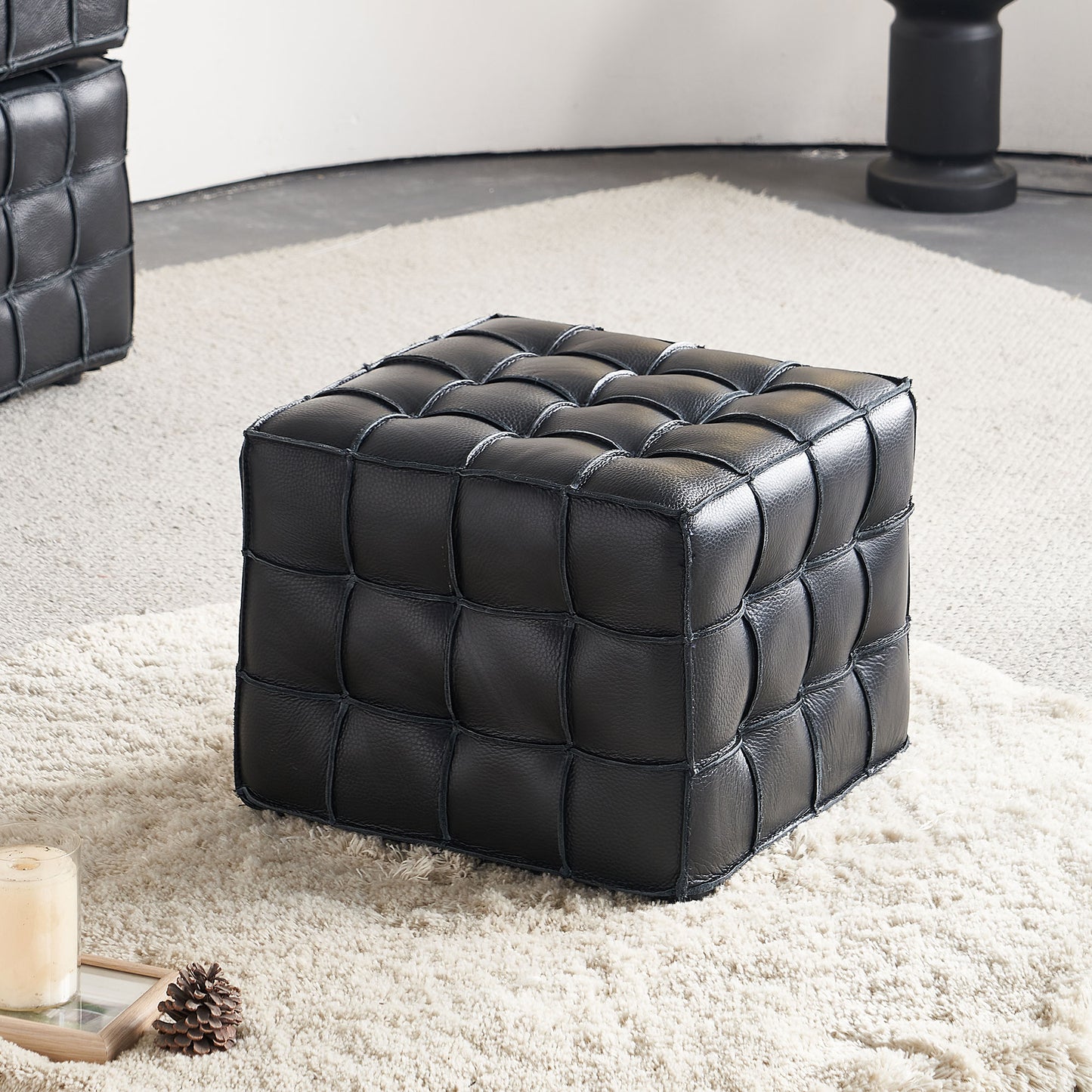 Black leather cube ottoman with stitched square pattern perfect for living room accent