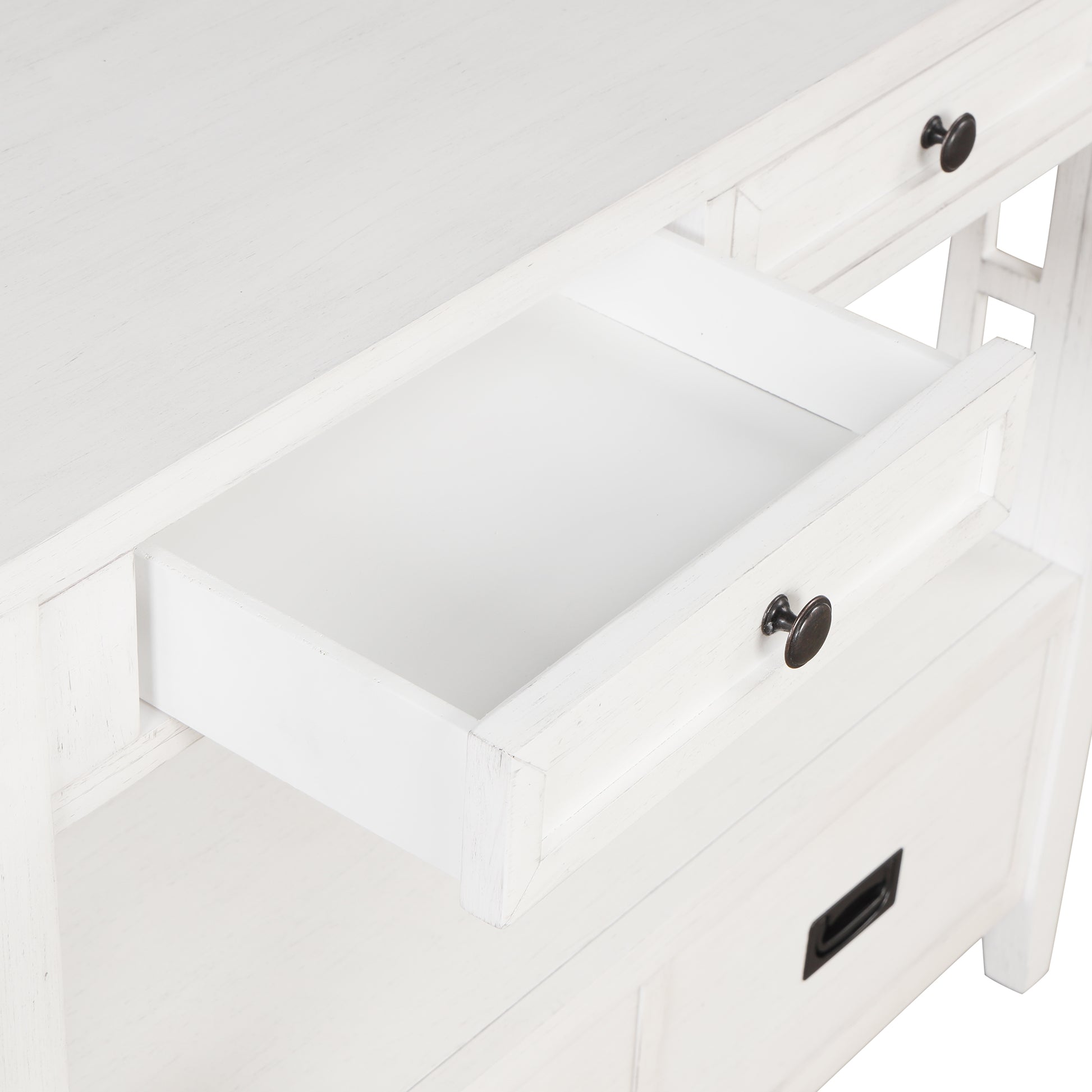 Closeup of a white distressed wood desk with an open drawer and antique bronze knobs