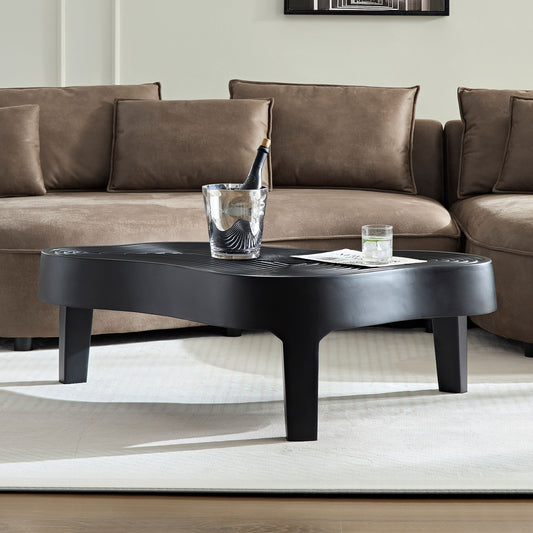 Black modern coffee table with wavy top and tapered legs perfect for living rooms