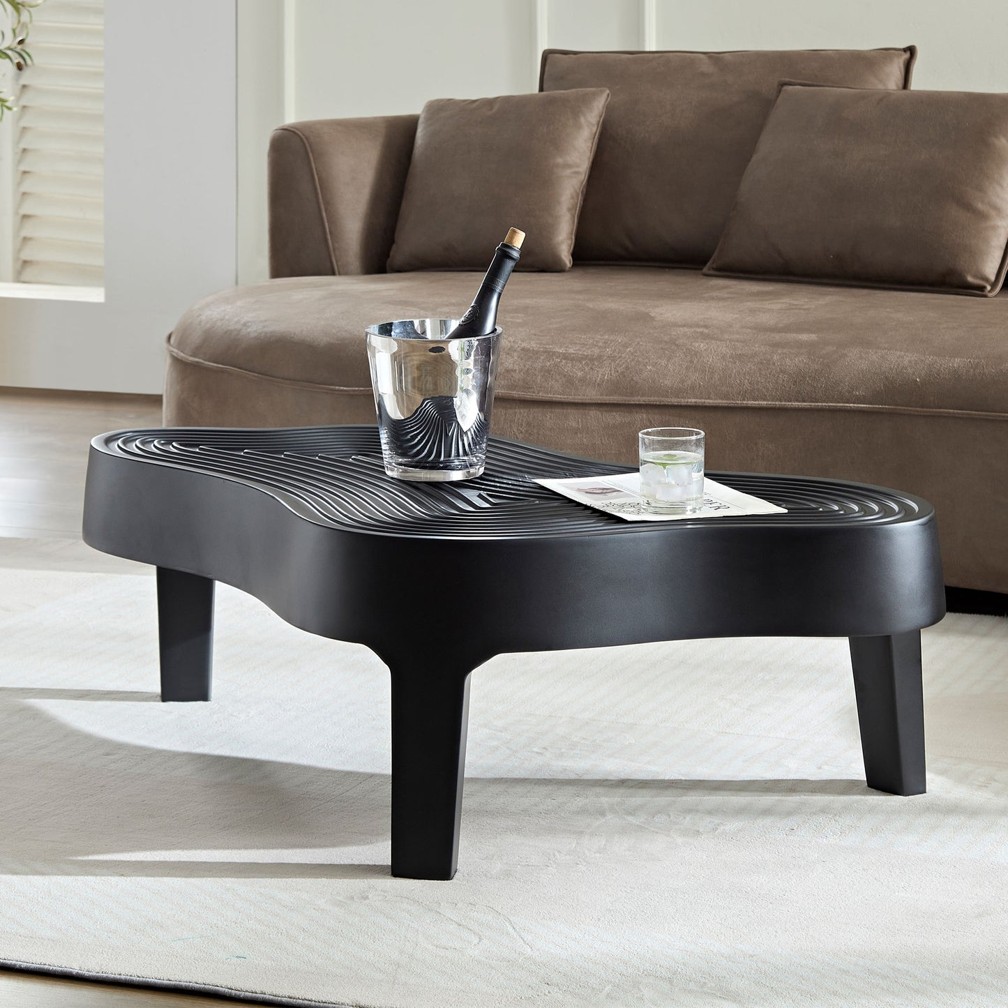 Modern black wavy coffee table with metallic ice bucket and drink