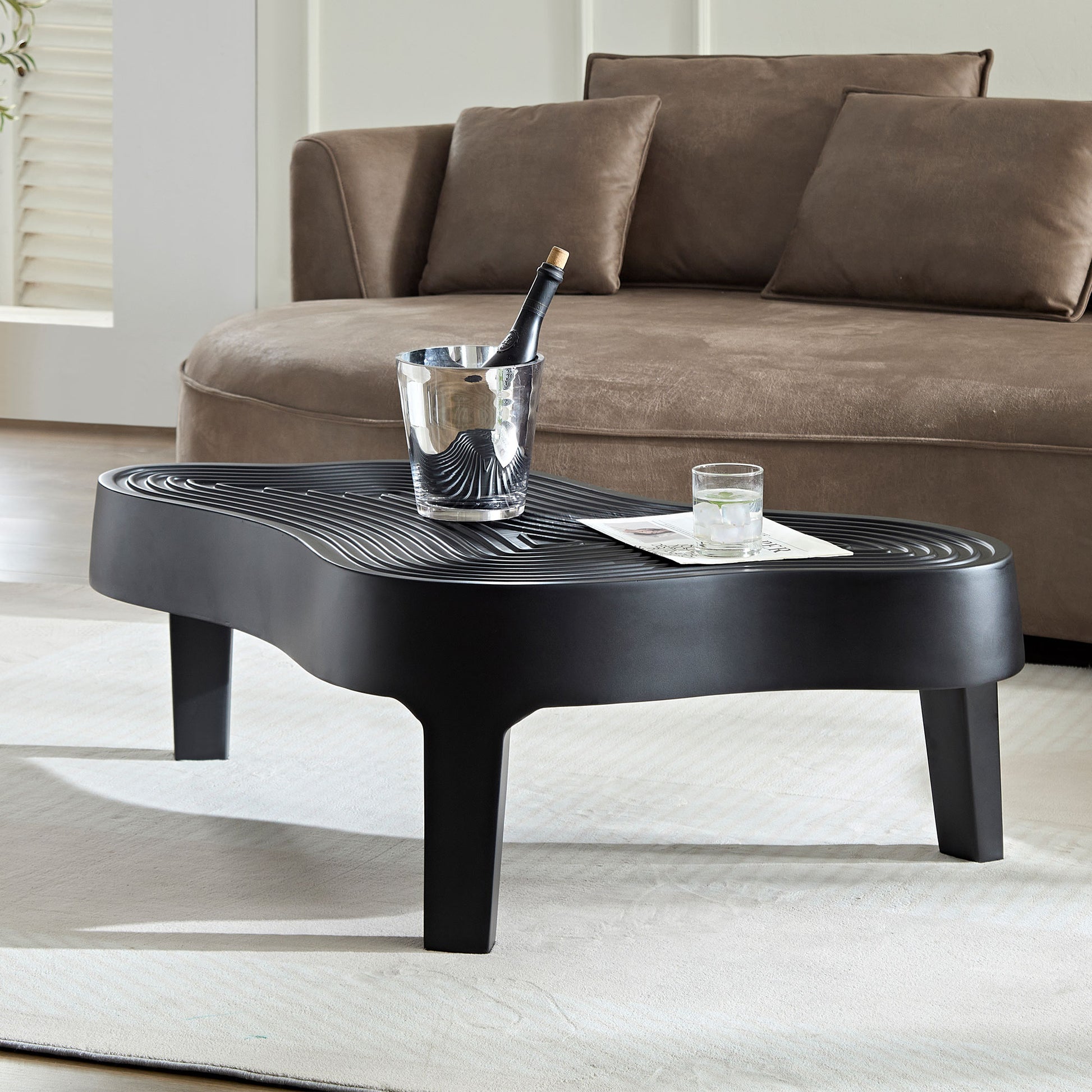 Modern black wavy coffee table with metallic ice bucket and drink