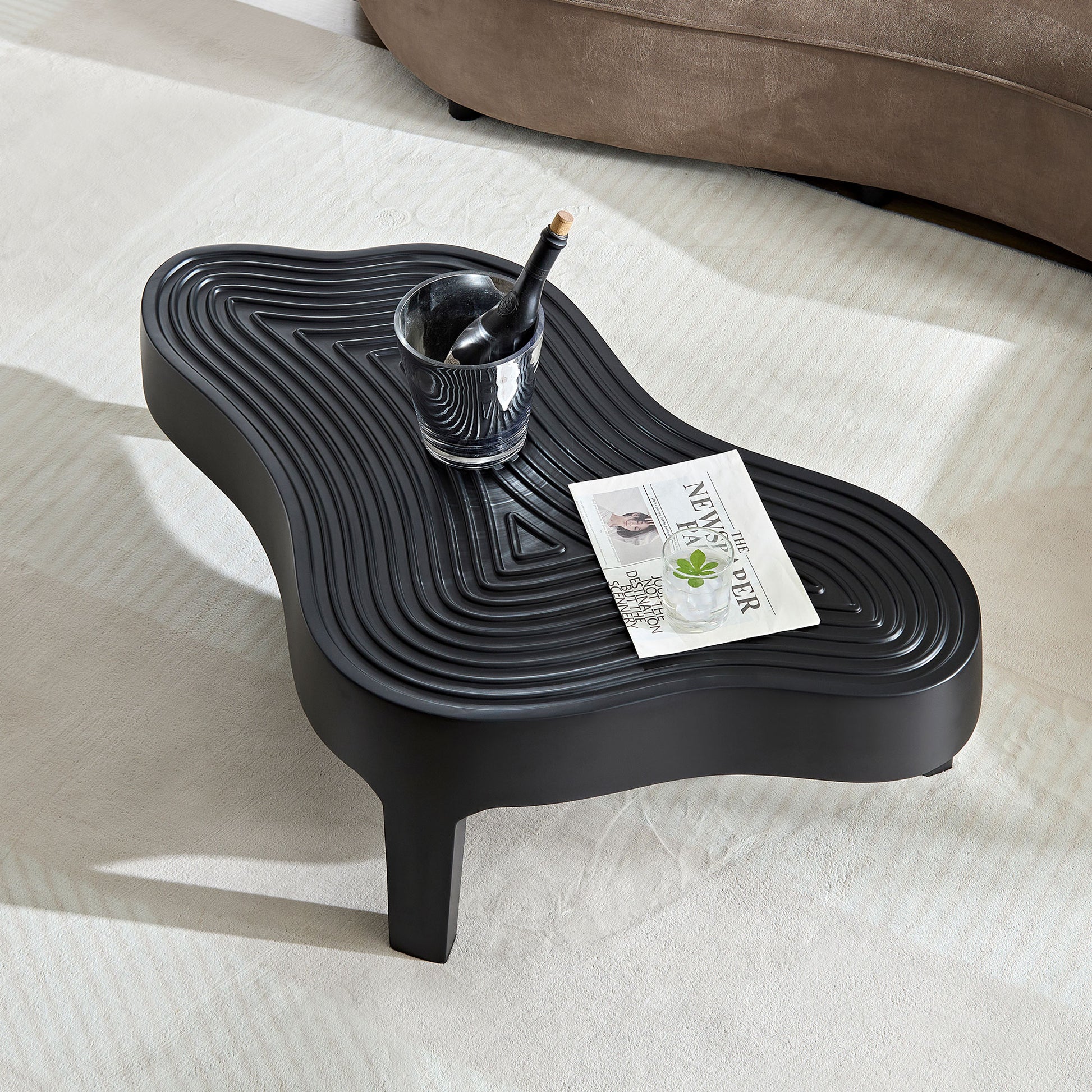 Sculptural black coffee table with a rippled top design
