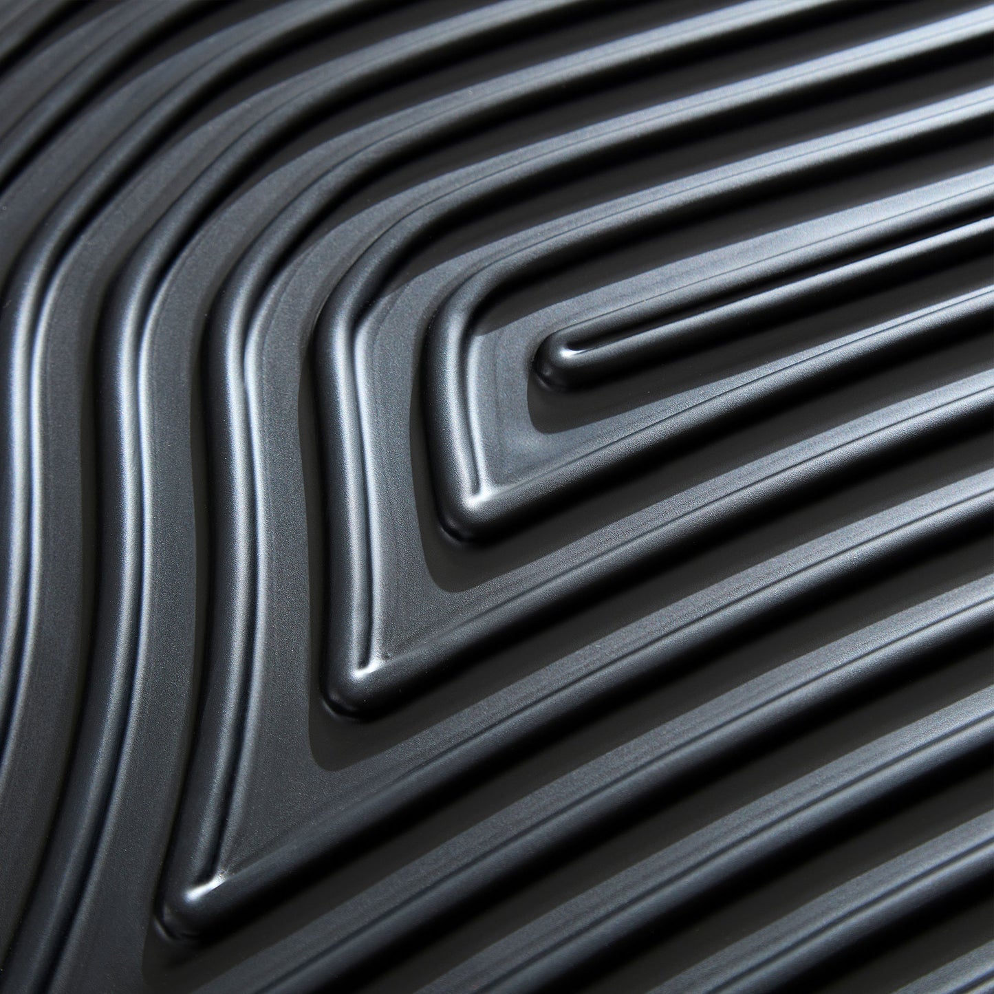 Closeup of dark gray textured luggage shell with repeating linear pattern