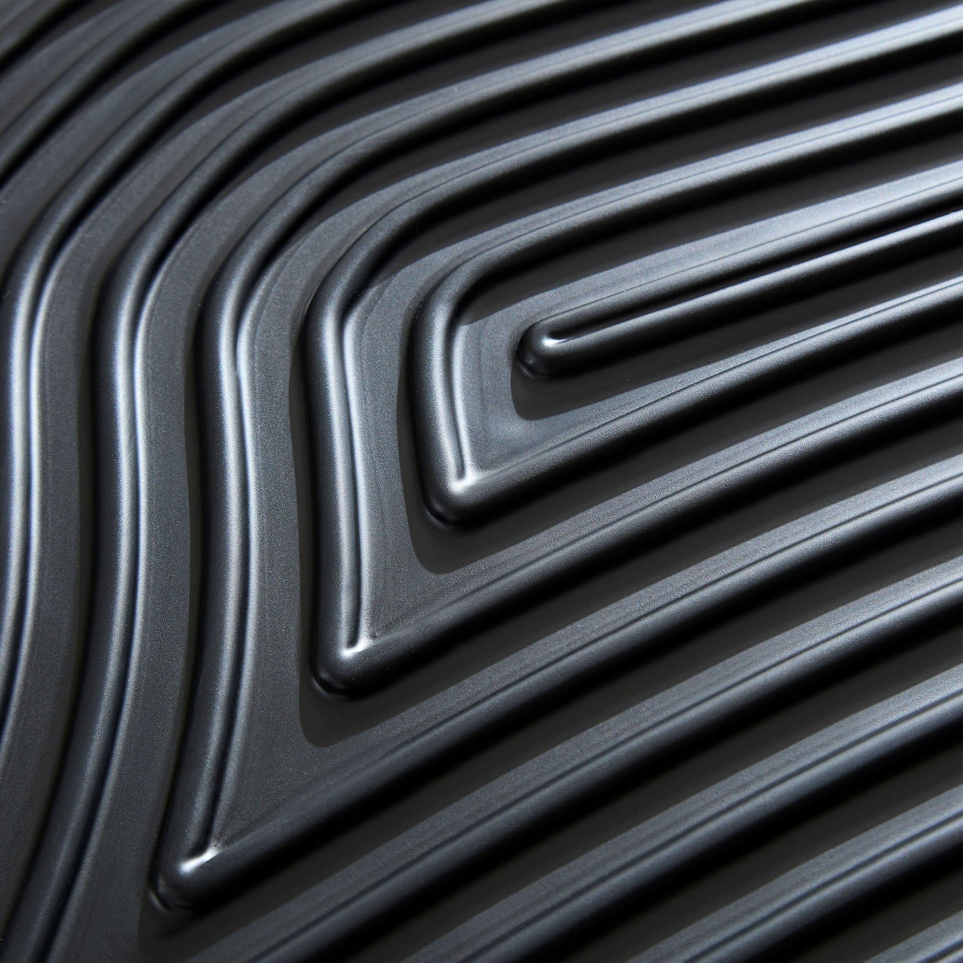 Closeup of dark gray textured luggage shell with repeating linear pattern