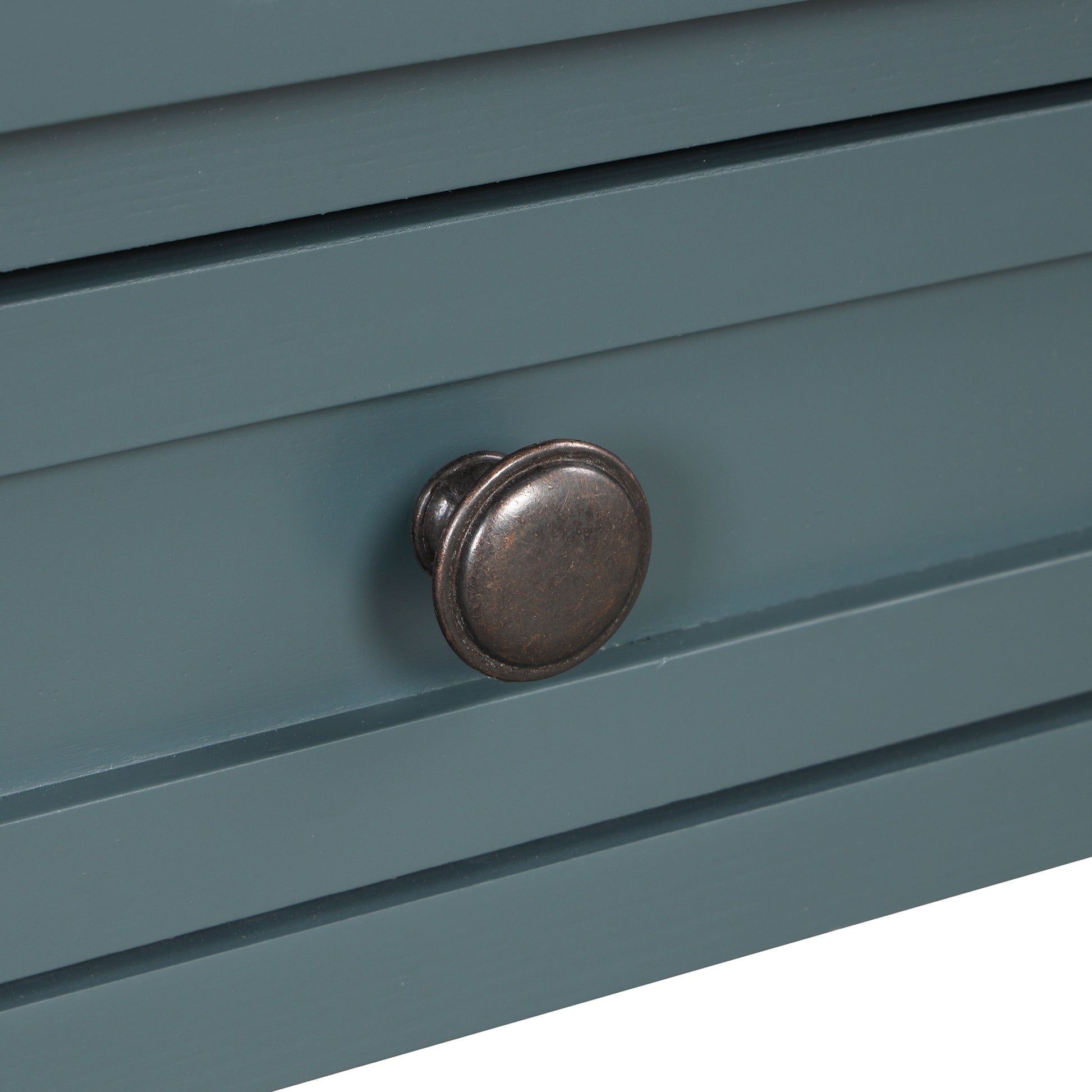 Close up of a vintagestyle dresser drawer with a round bronze knob and slate blue finish