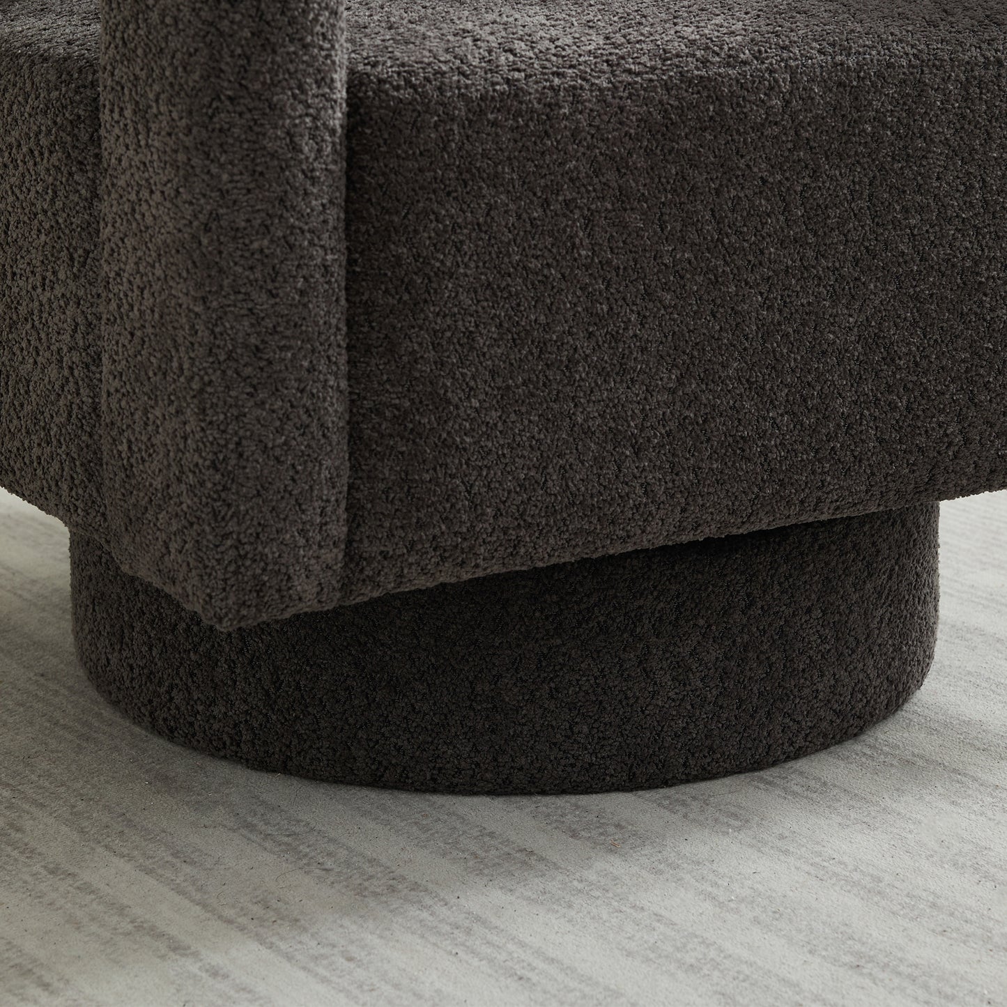 Closeup of dark grey boucle fabric on a swivel chair base