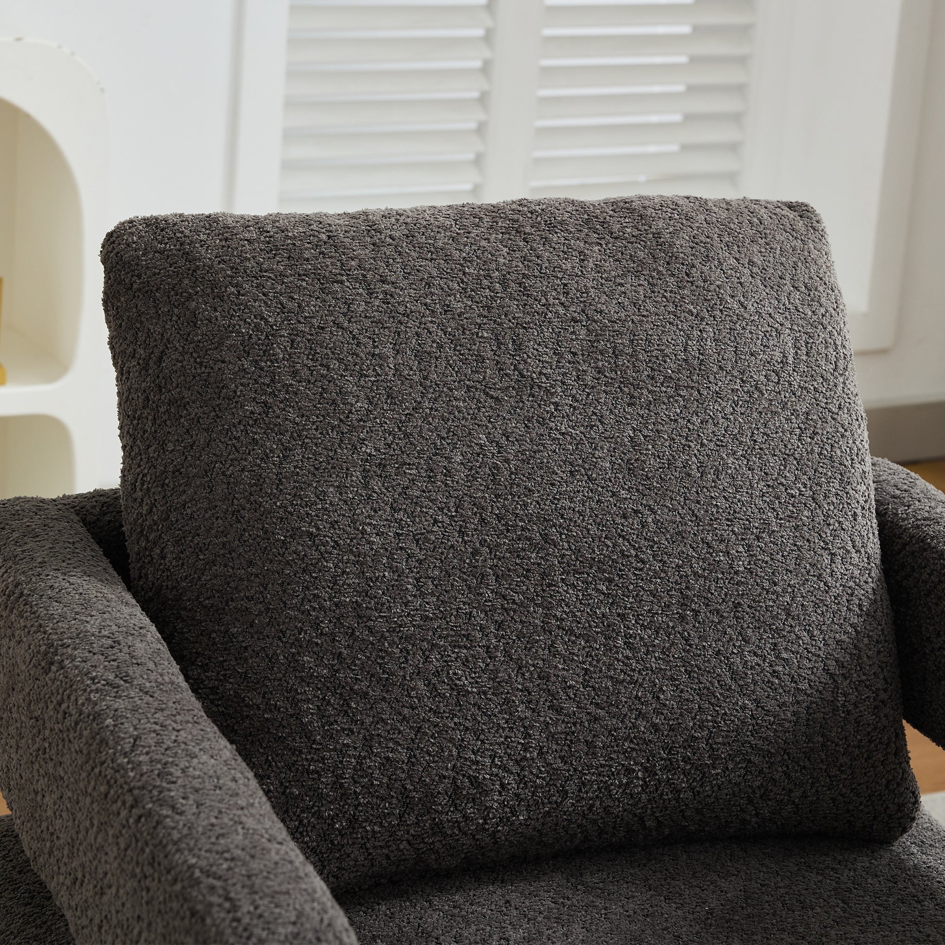 Plush dark gray armchair cushion with a textured boucle fabric finish