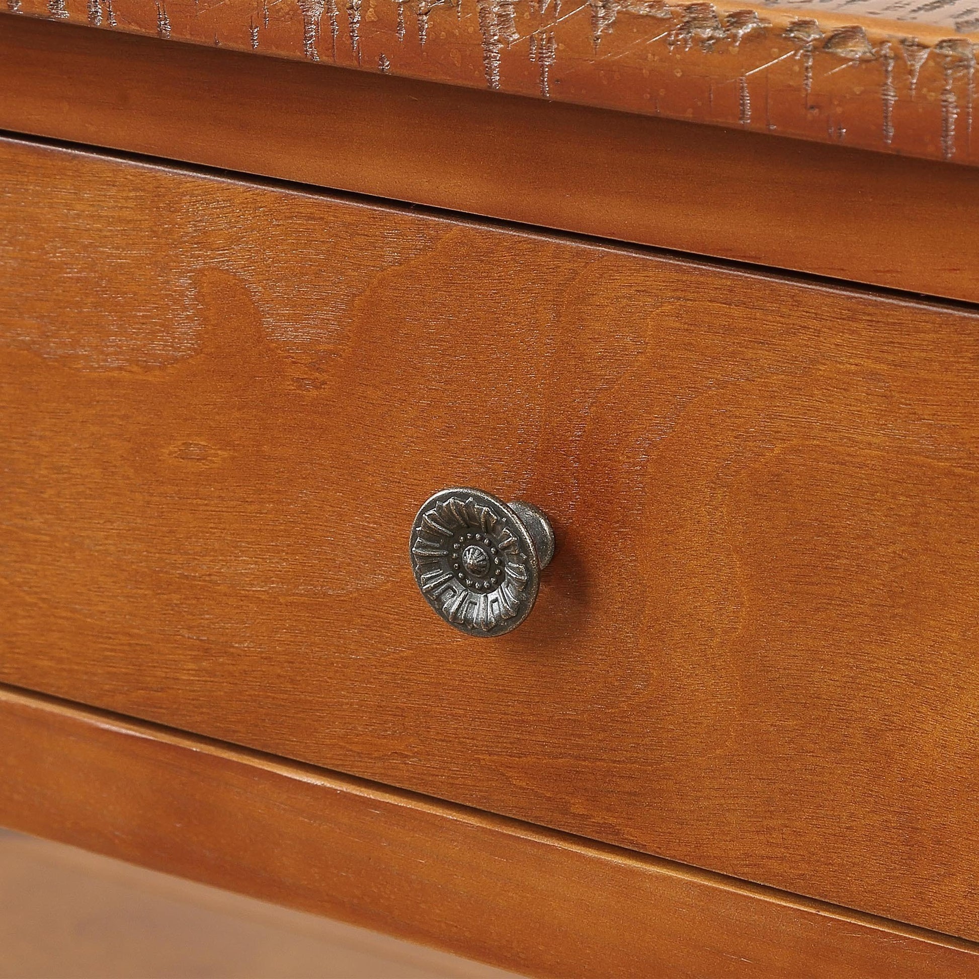 Closeup of antique brass drawer pull on a distressed wood dresser drawer