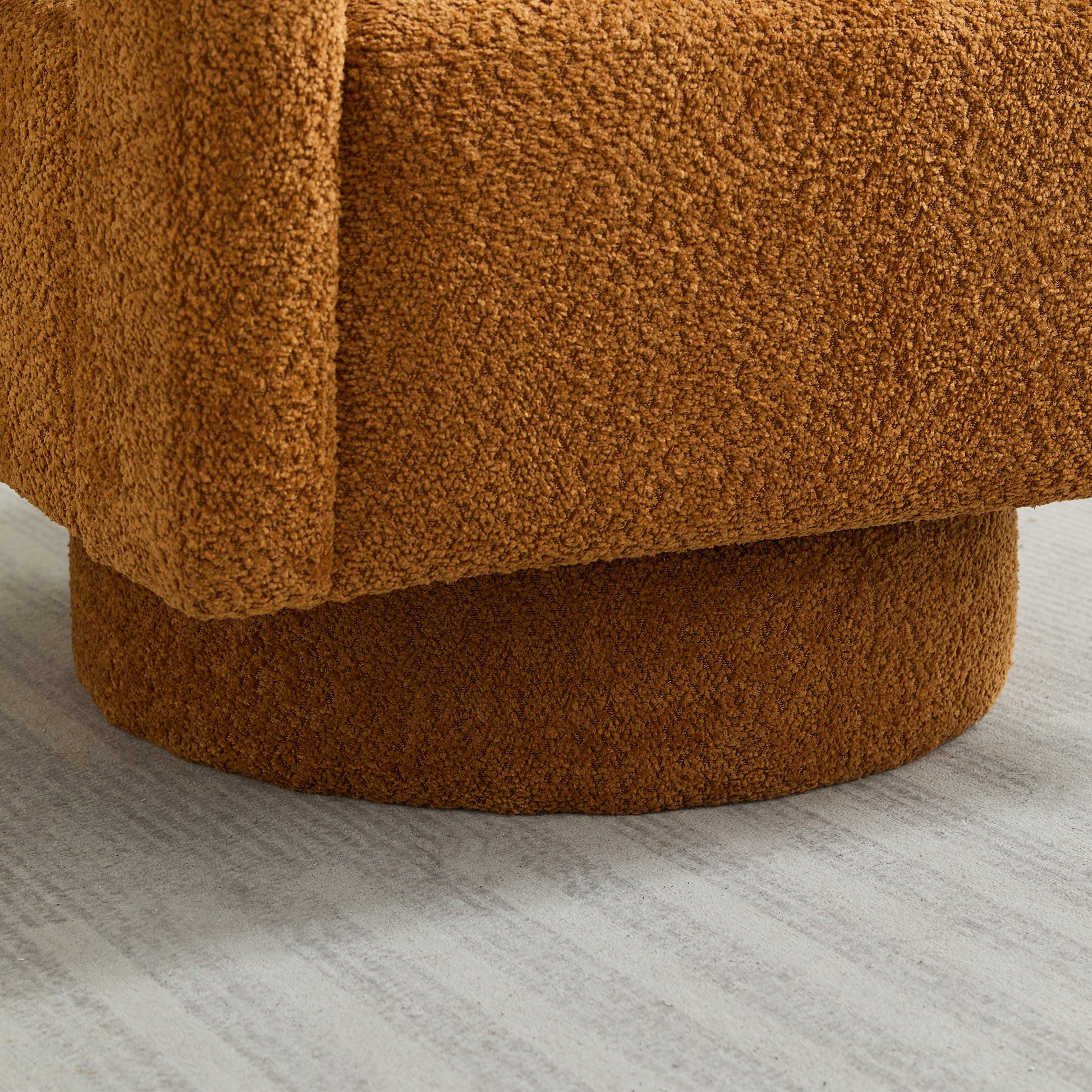 Closeup of a plush caramelcolored boucle fabric armchair showing its textured upholstery