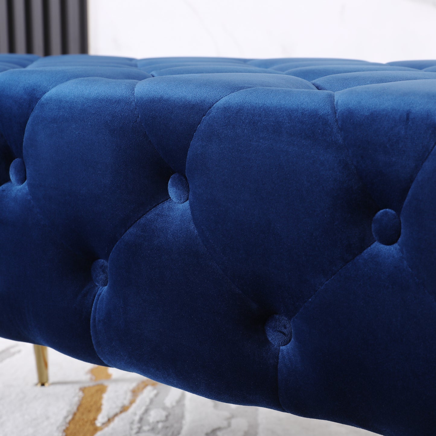 Deep blue velvet upholstered bench with button tufting detail