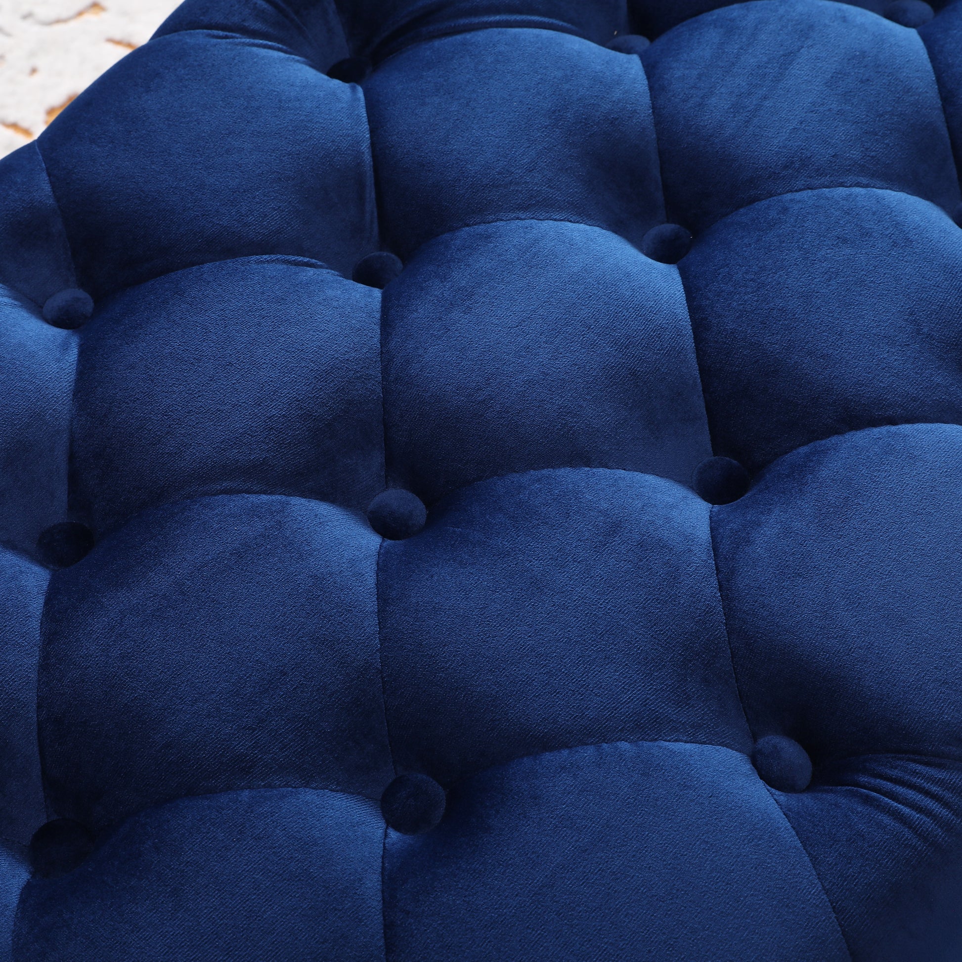 Deep navy blue velvet ottoman with tufted buttons perfect for footrest or accent seating