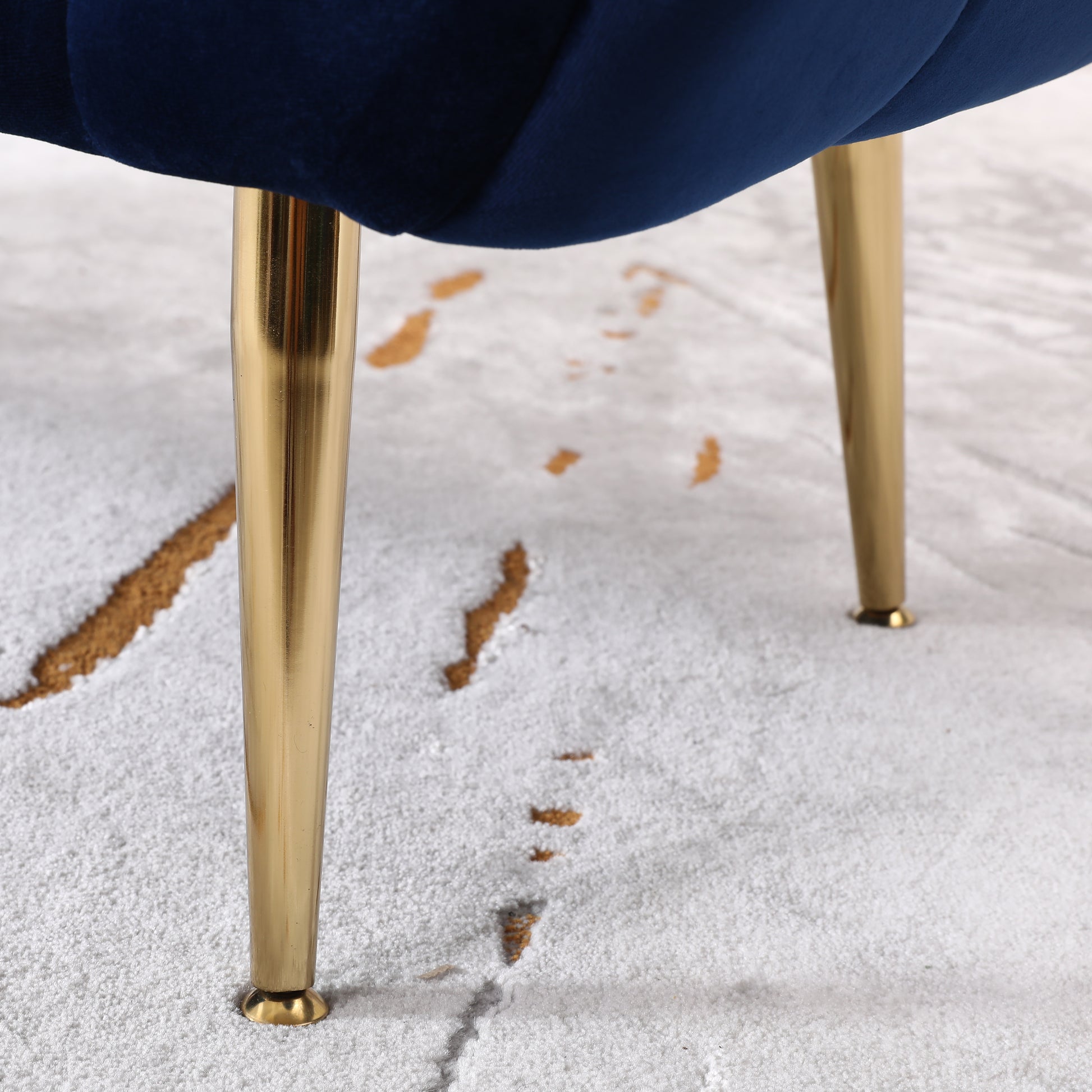 Deep blue velvet tufted chair legs with gold accents