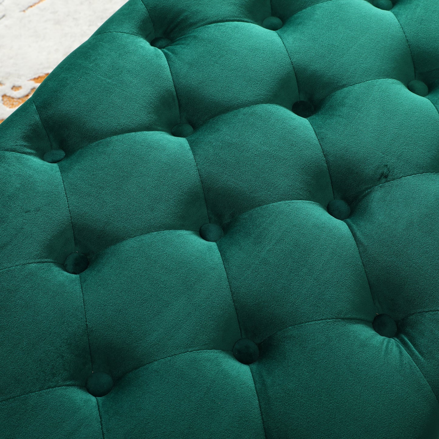 Closeup of tufted deep emerald green velvet ottoman