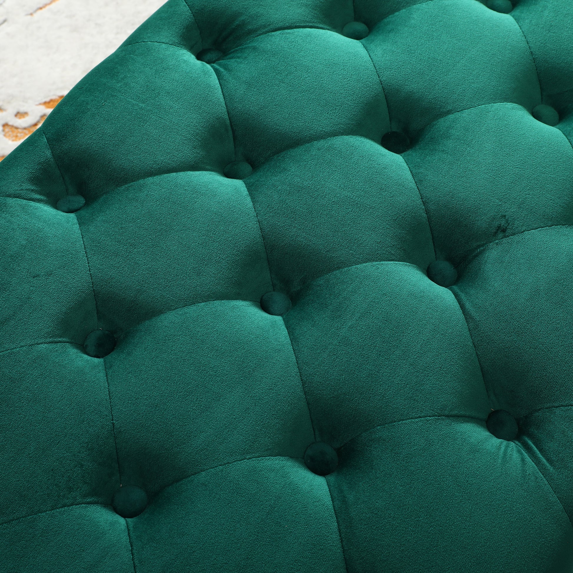 Closeup of tufted deep emerald green velvet ottoman