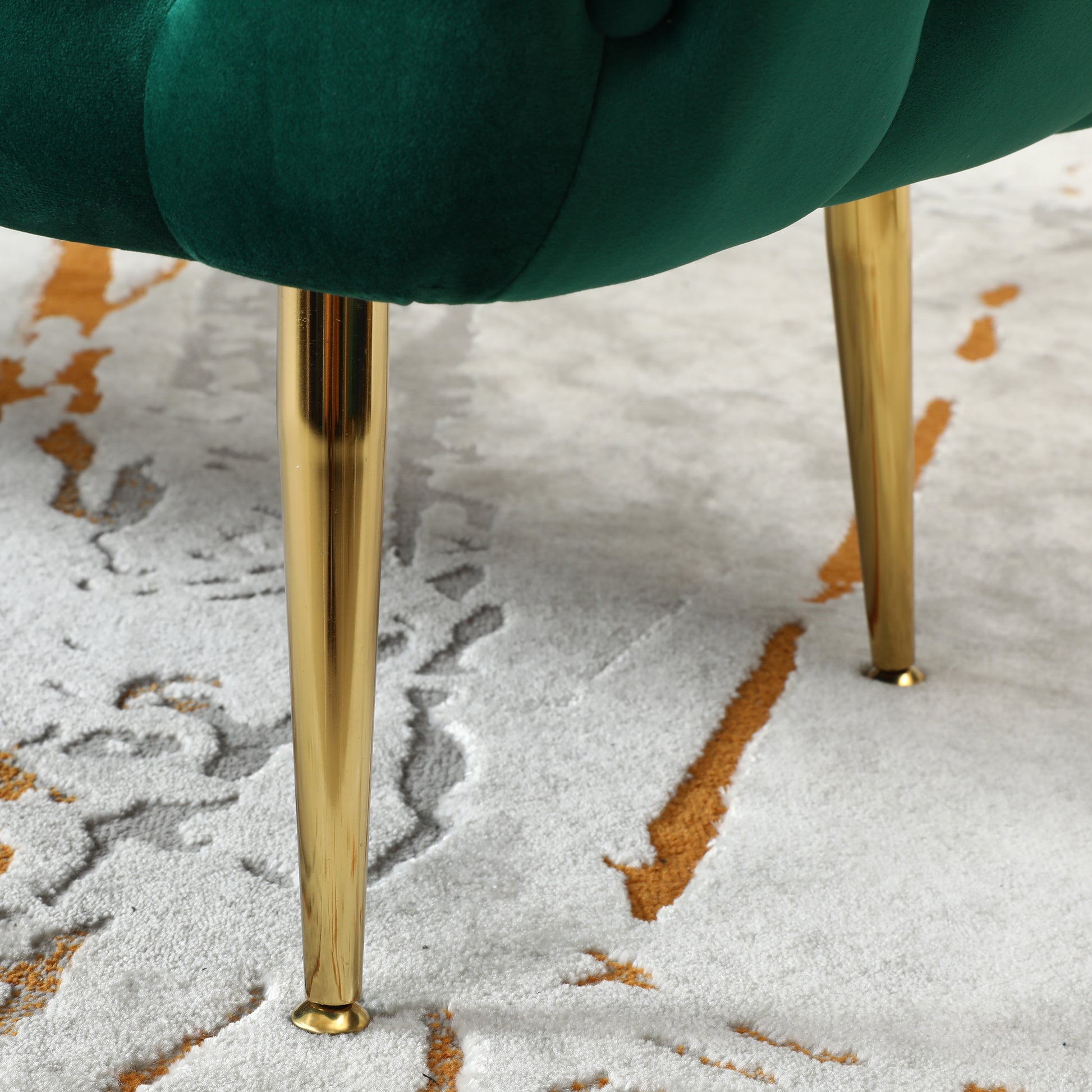 Deep emerald velvet armchair detail with elegant gold legs