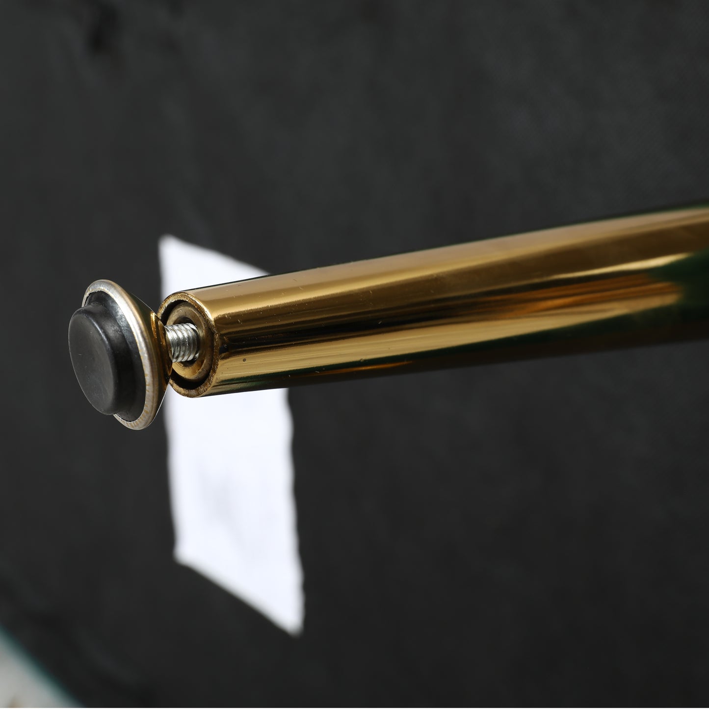 Golden metal furniture leg with black foot protector