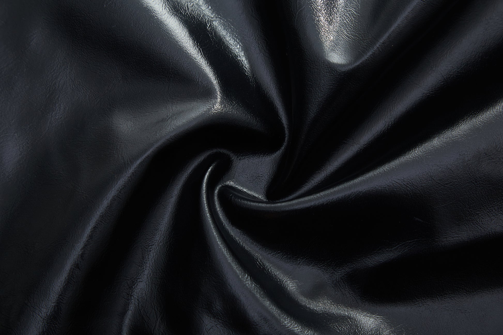 Closeup of black faux leather fabric with subtle texture and sheen