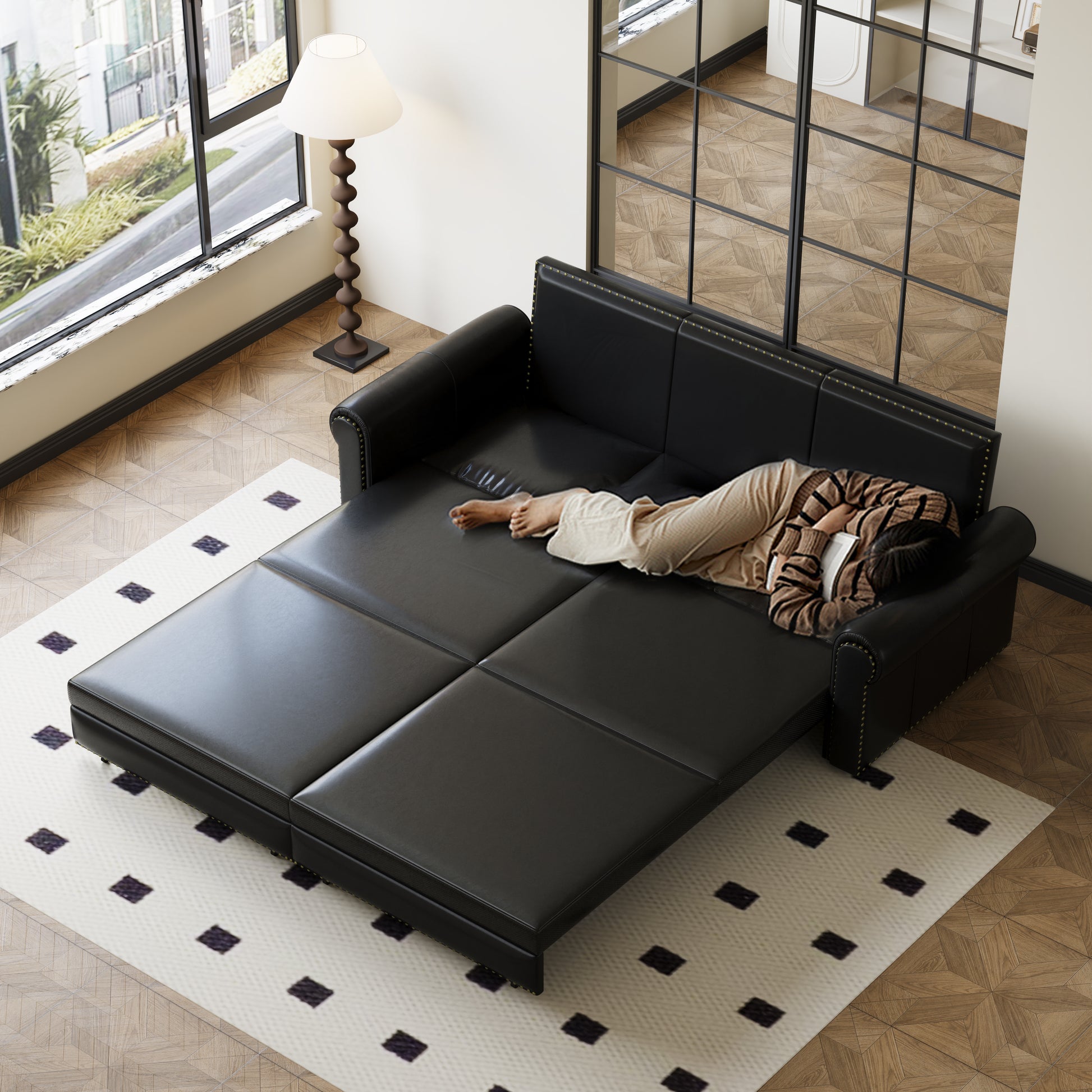 Black leather sofa bed with studded trim perfect for small living spaces