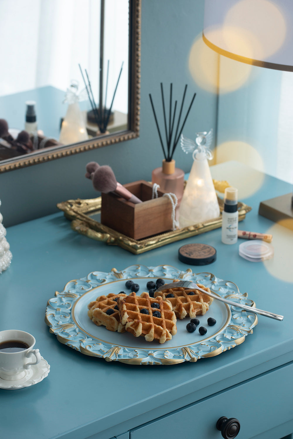 Golden Belgian waffles with blueberries on a decorative plate and coffee