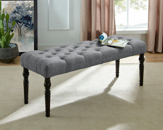 Grey fabric tufted bench with dark wood legs
