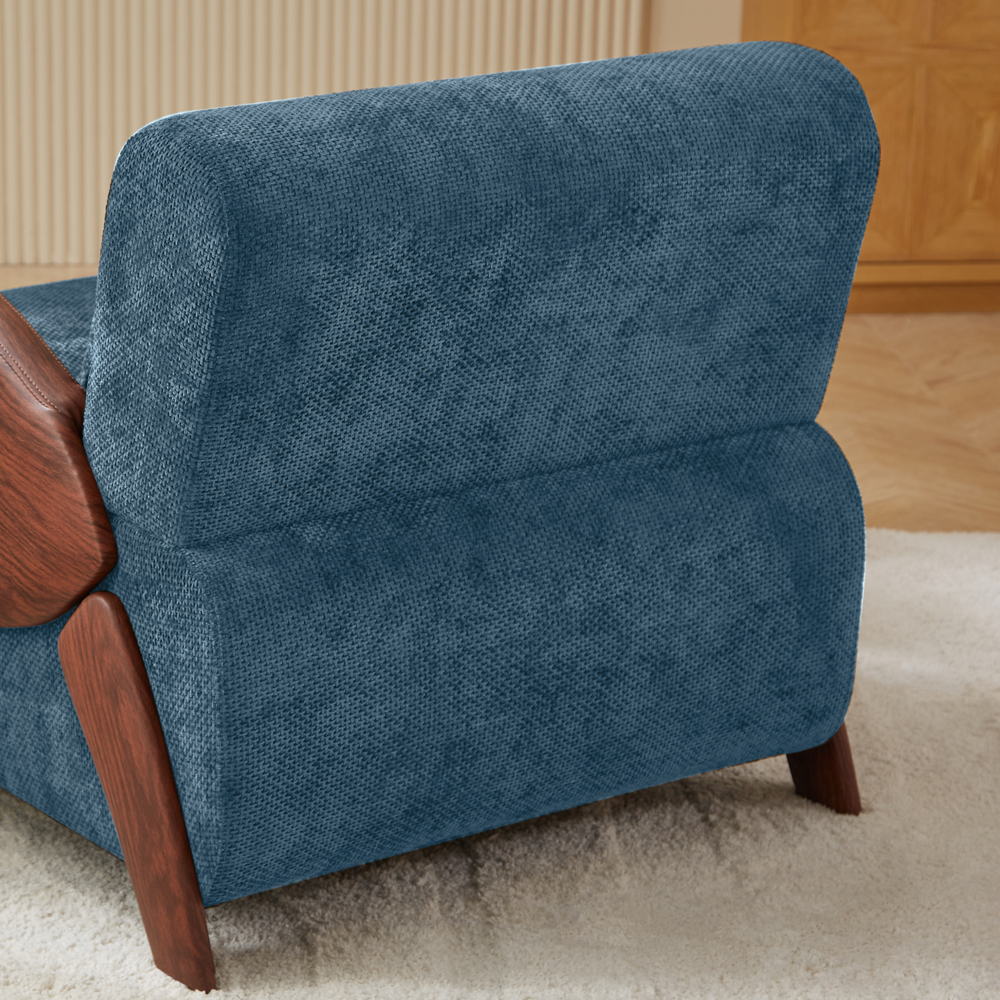 Deep blue upholstered accent chair with rich wood accents and a textured finish