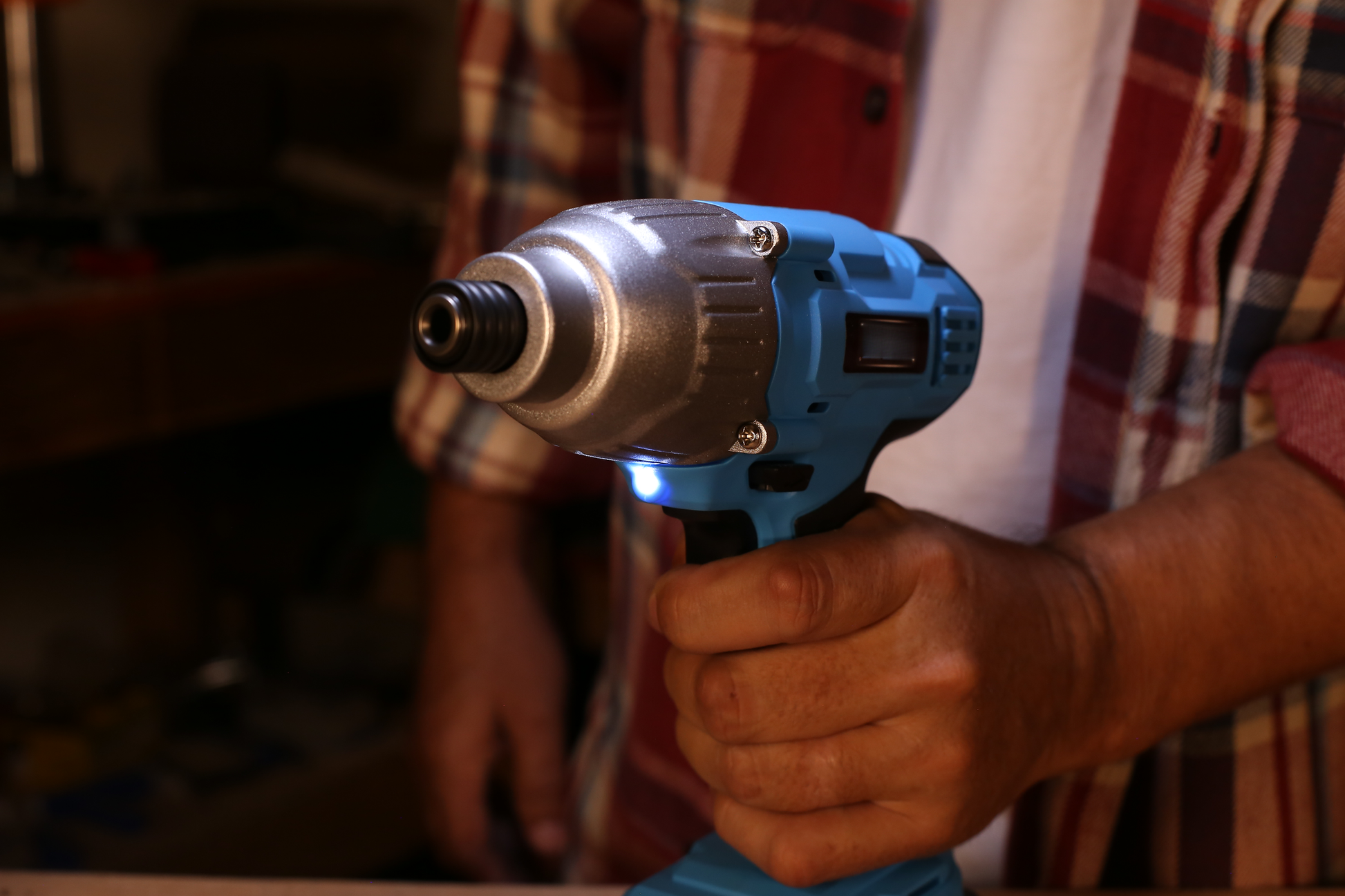 Blue and silver cordless impact driver held by hand