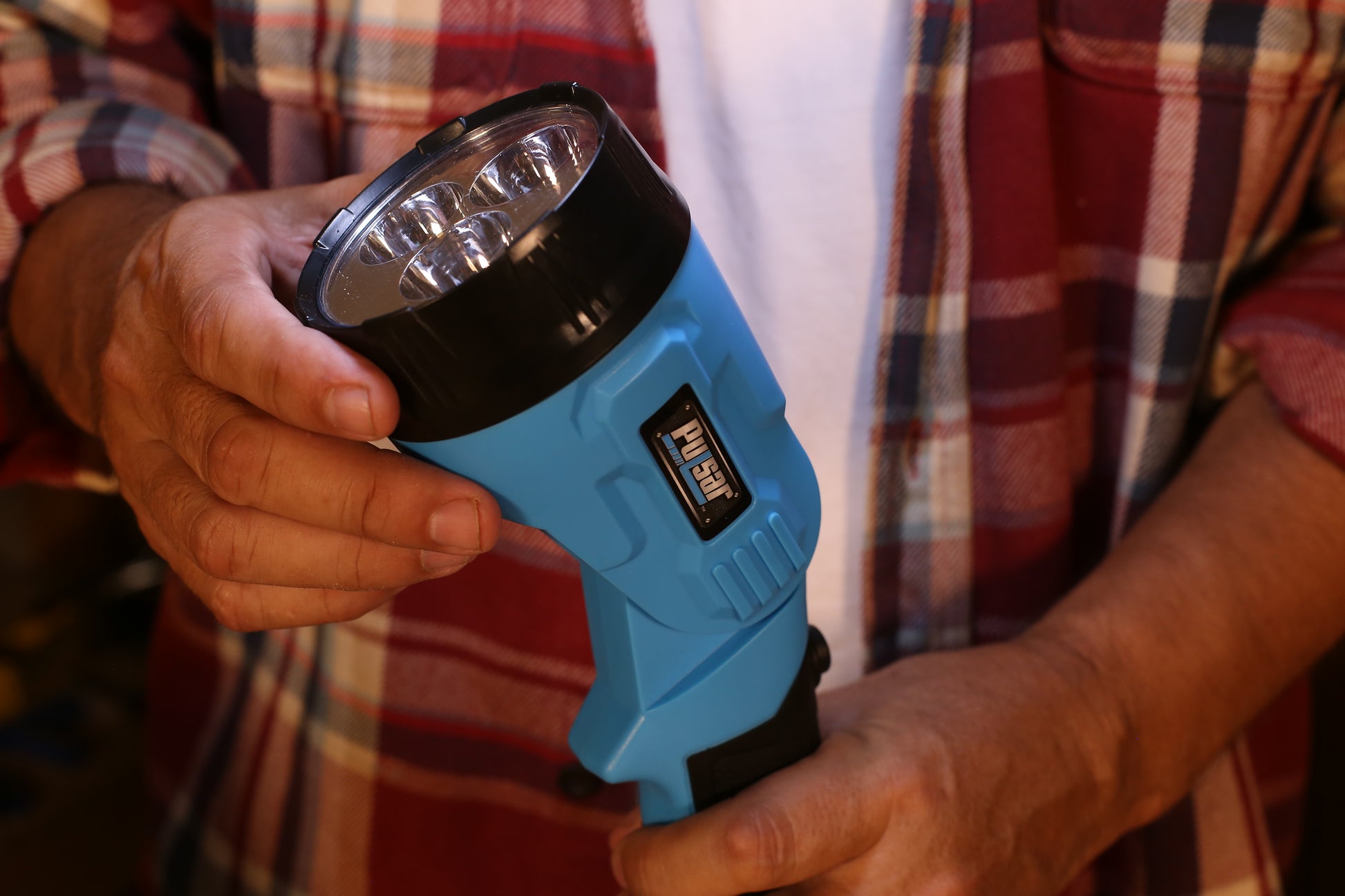 Blue Pulsar flashlight with  LED bulbs held by hands