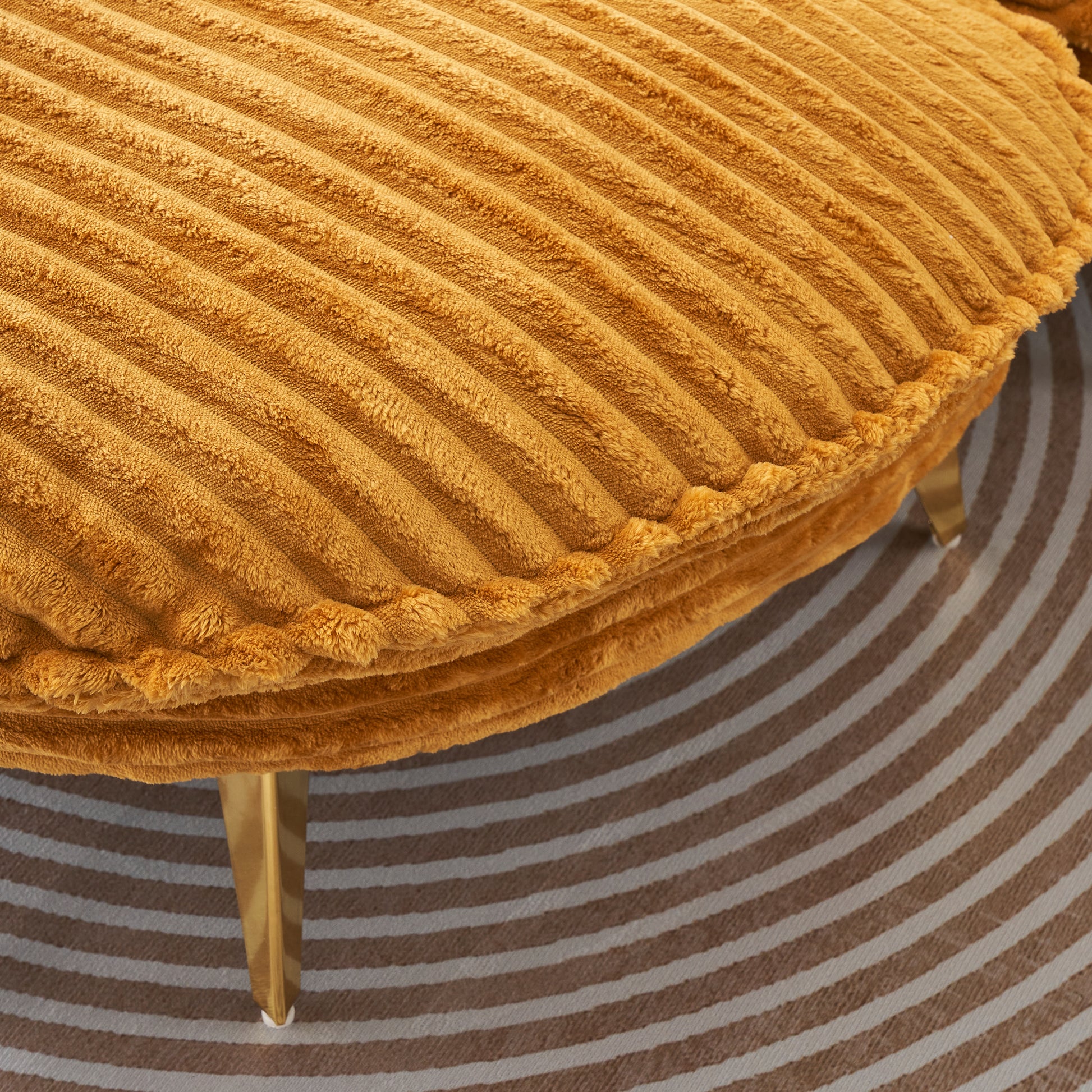 Mustard yellow corduroy ottoman with plush texture and brushed gold legs