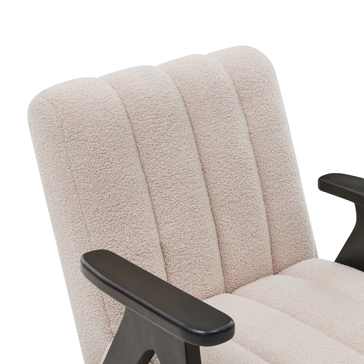 Closeup of a plush cream boucle chair armrest with dark wood accents exuding modern comfort