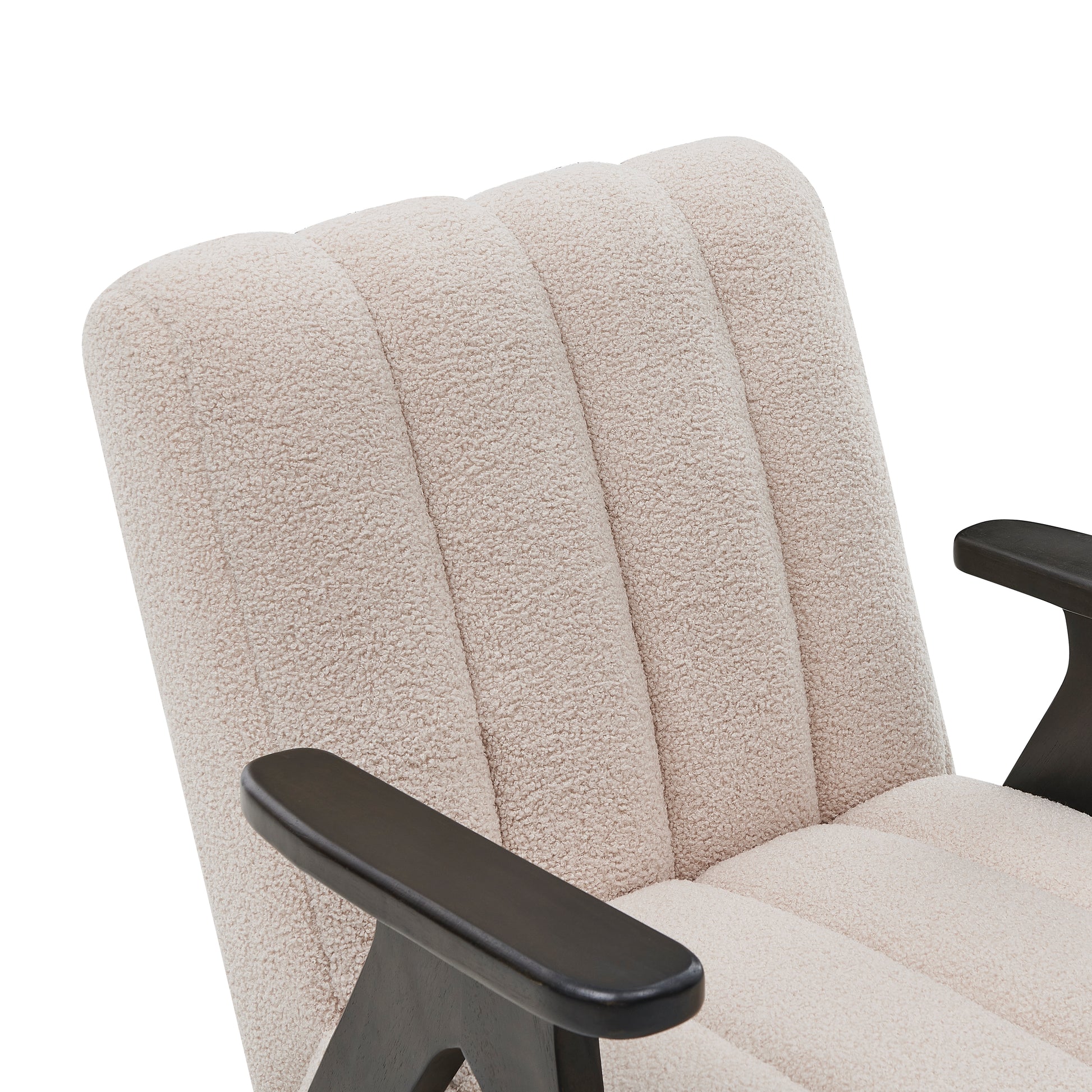 Closeup of a plush cream boucle chair armrest with dark wood accents exuding modern comfort