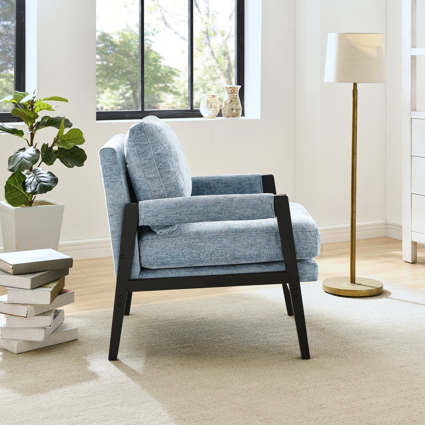 Cozy light blue upholstered armchair with black wood frame perfect for reading nook