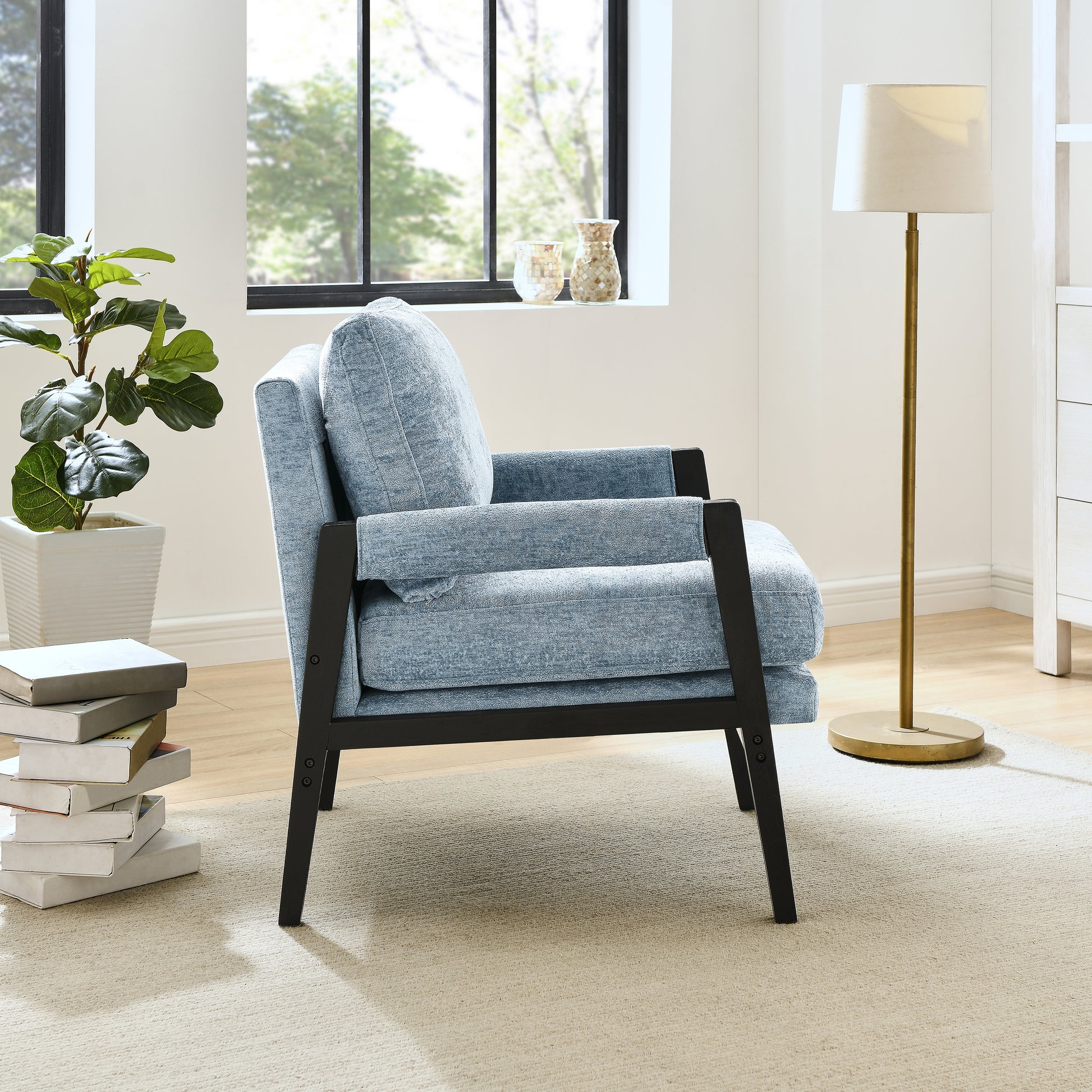 Cozy light blue upholstered armchair with black wood frame perfect for reading nook
