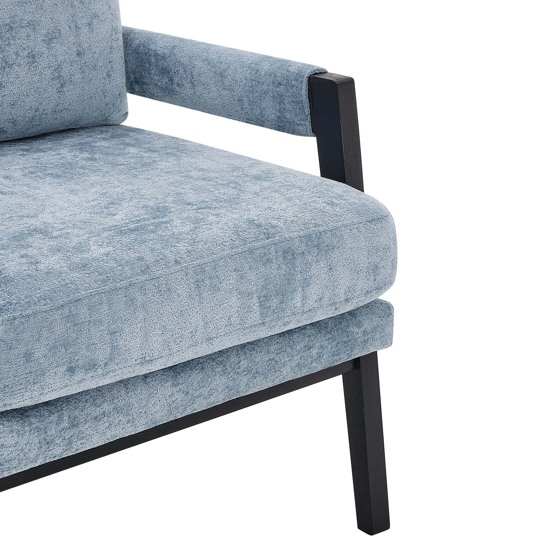 Closeup of a textured light blue upholstered armchair with dark wooden legs
