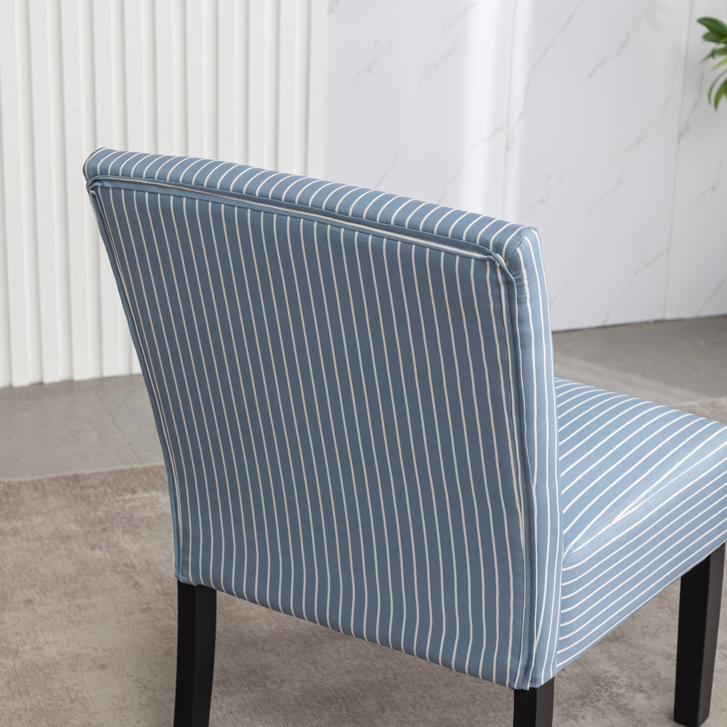 Closeup of a blue striped dining chair with white pinstripes upholstered fabric