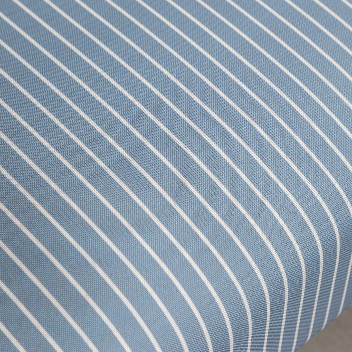 Closeup of blue and white striped fabric with a subtle texture ideal for upholstery
