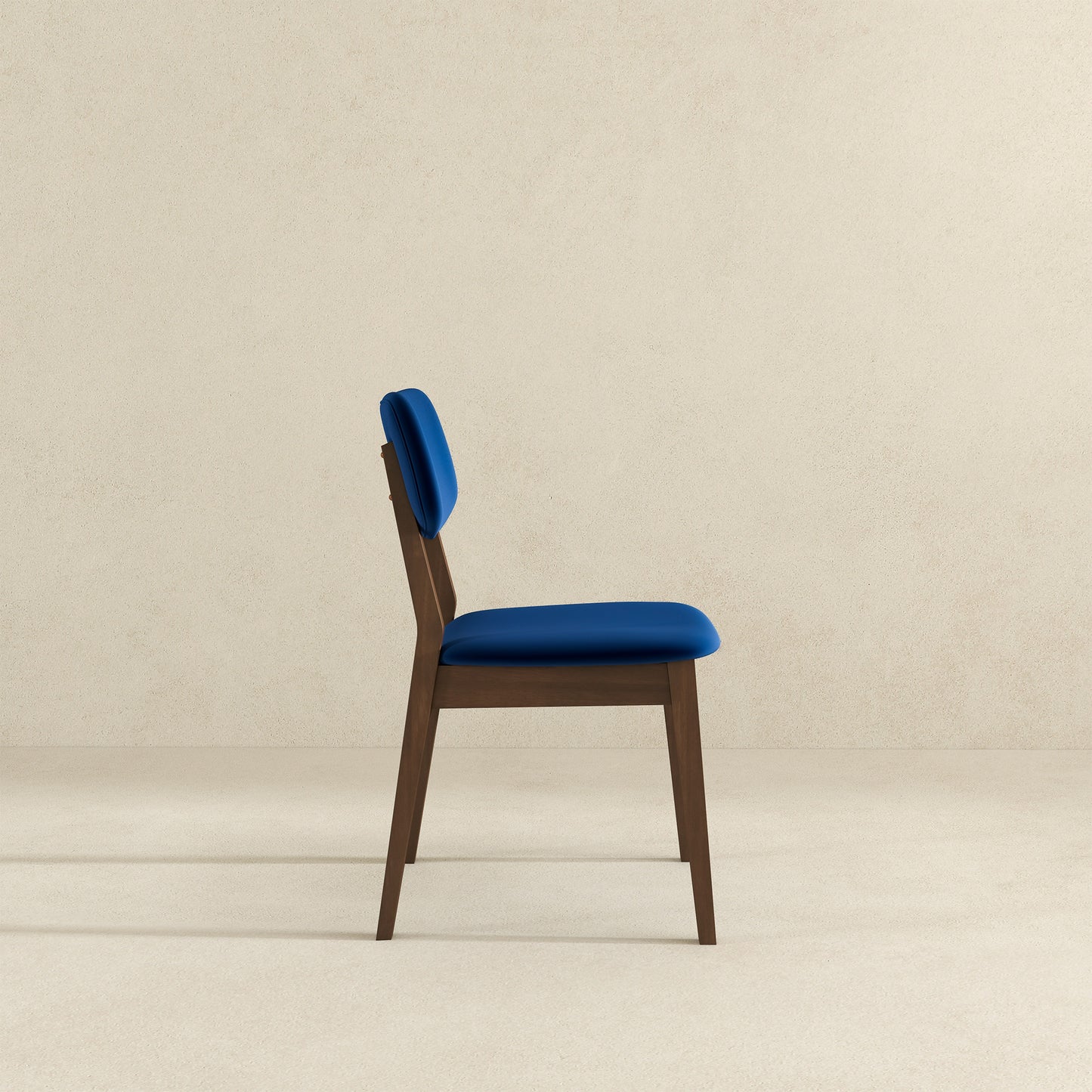 Side view of a blue velvet dining chair with a wooden frame modern design