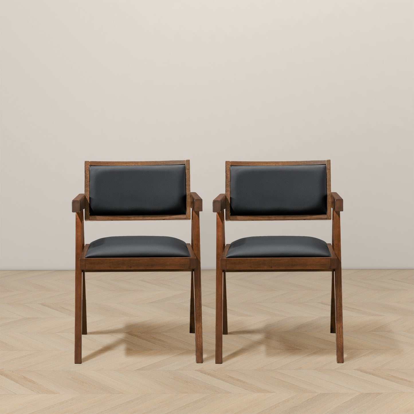 Two modern armchairs with dark wood frames and black leather upholstery