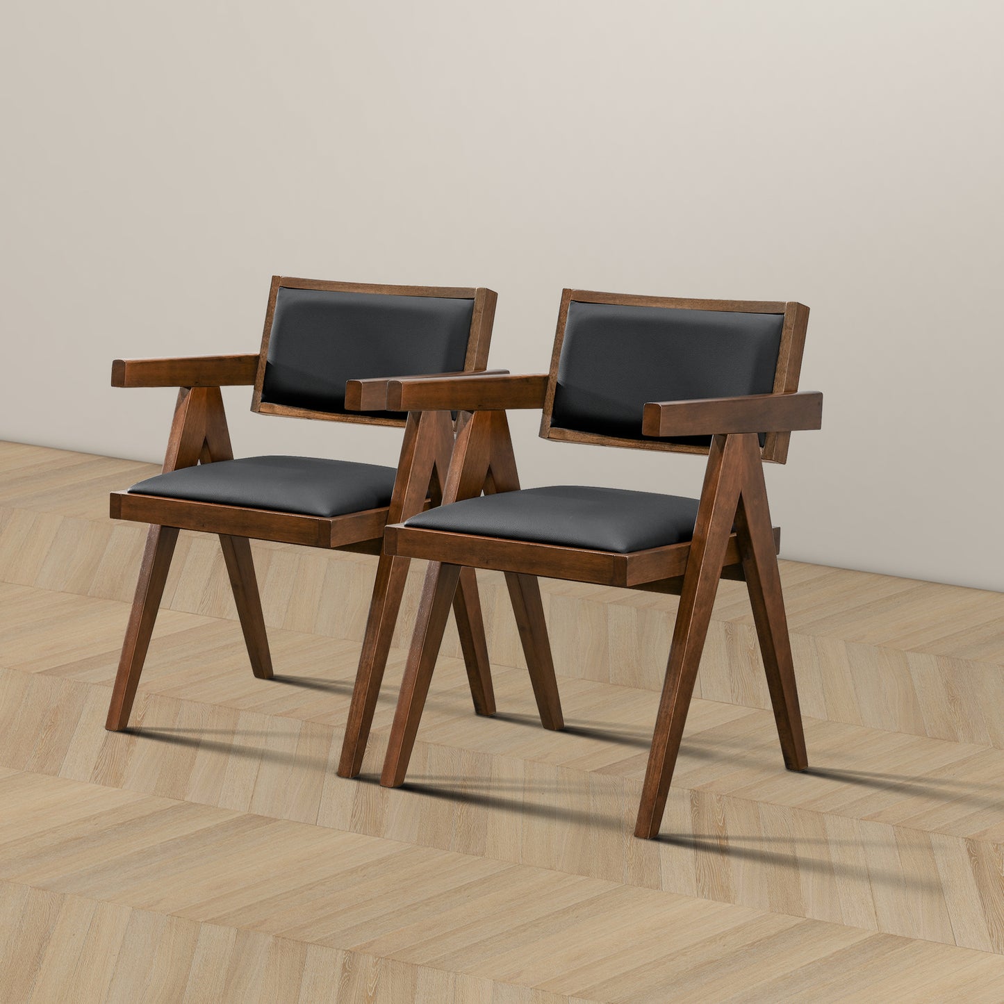 Two modern wooden dining chairs with black faux leather seats and backrests
